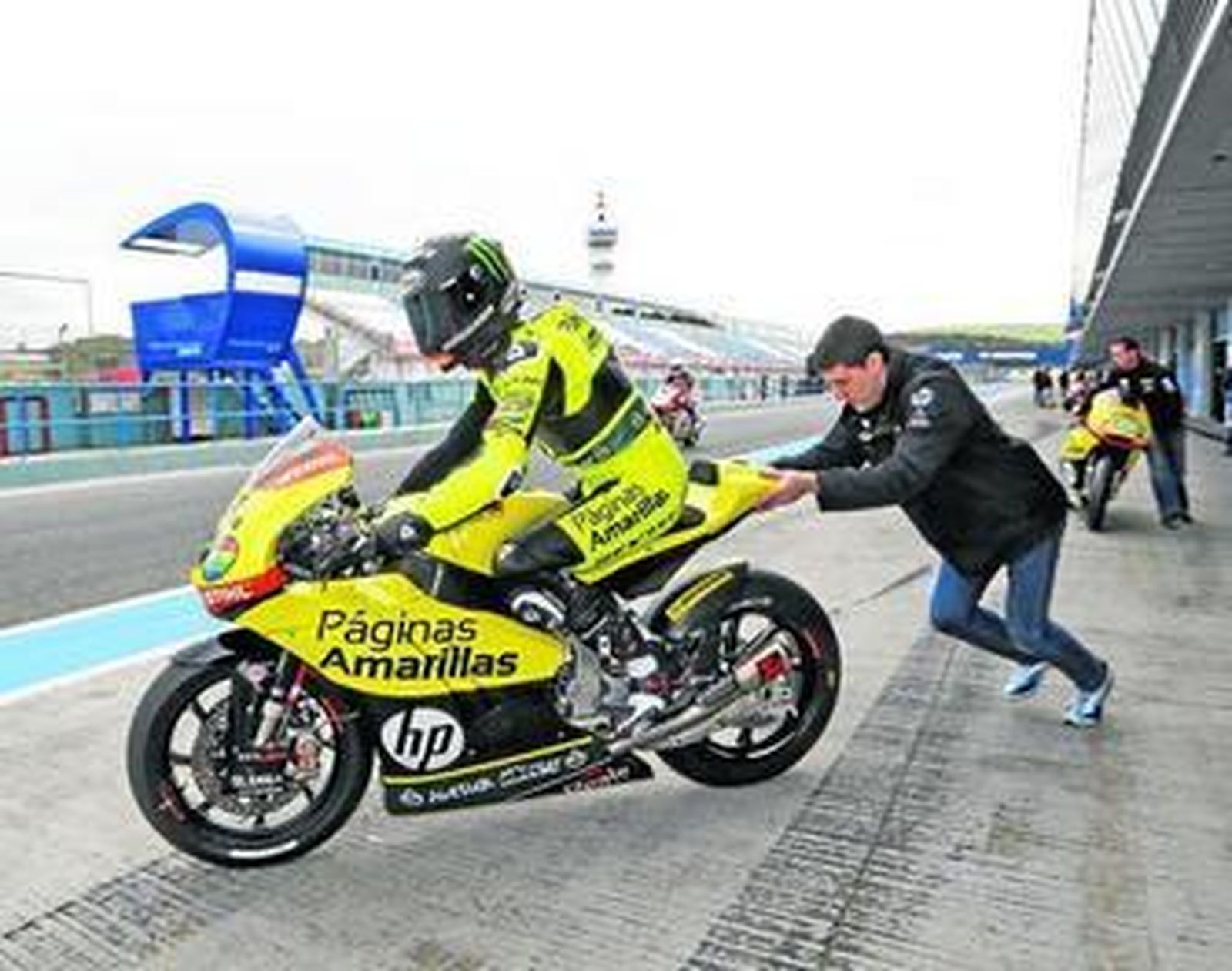 Alex Rins sale de su 'box' mientras un mecánico del Páginas Amarillas empuja su Kalex.