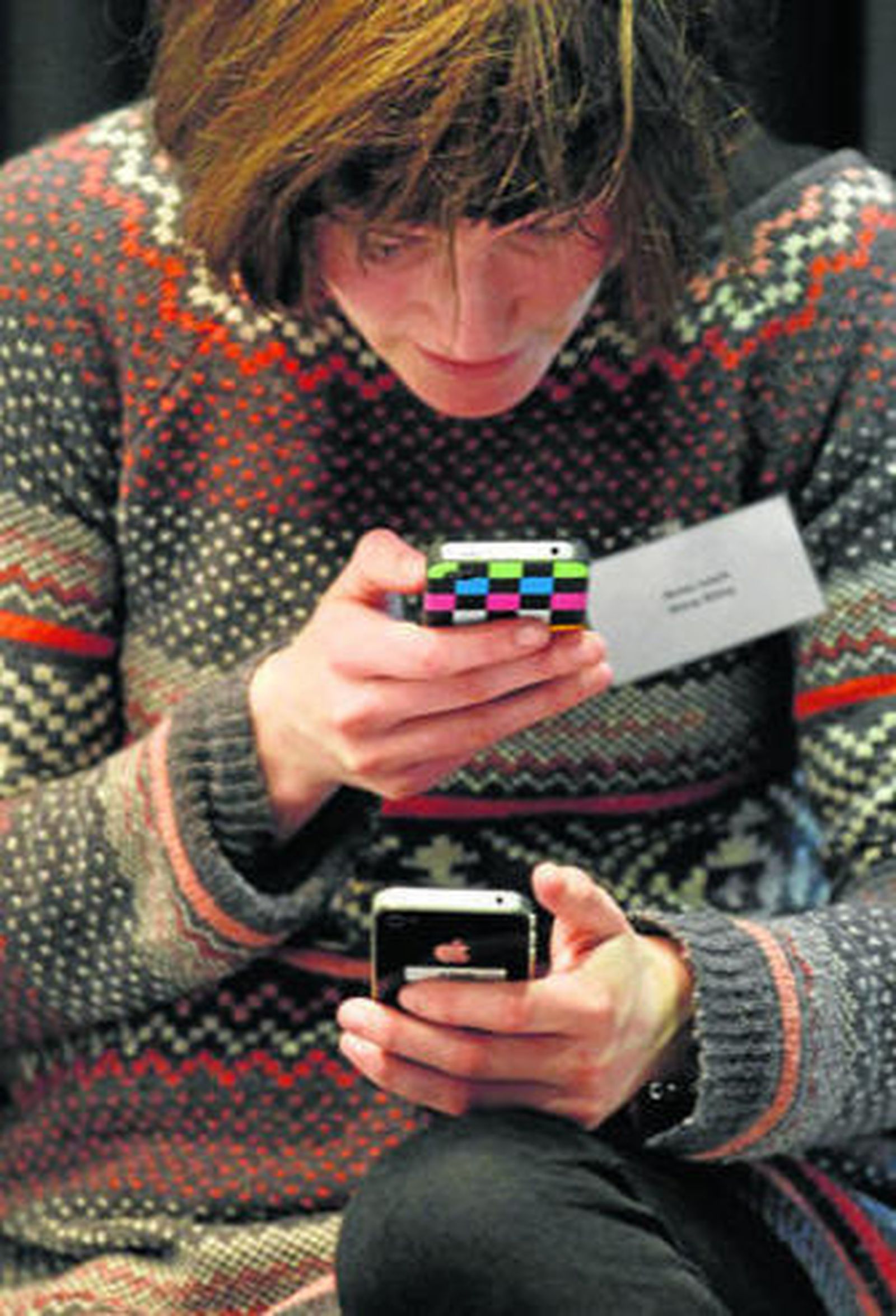 Una mujer observa sus datos en dos móviles.