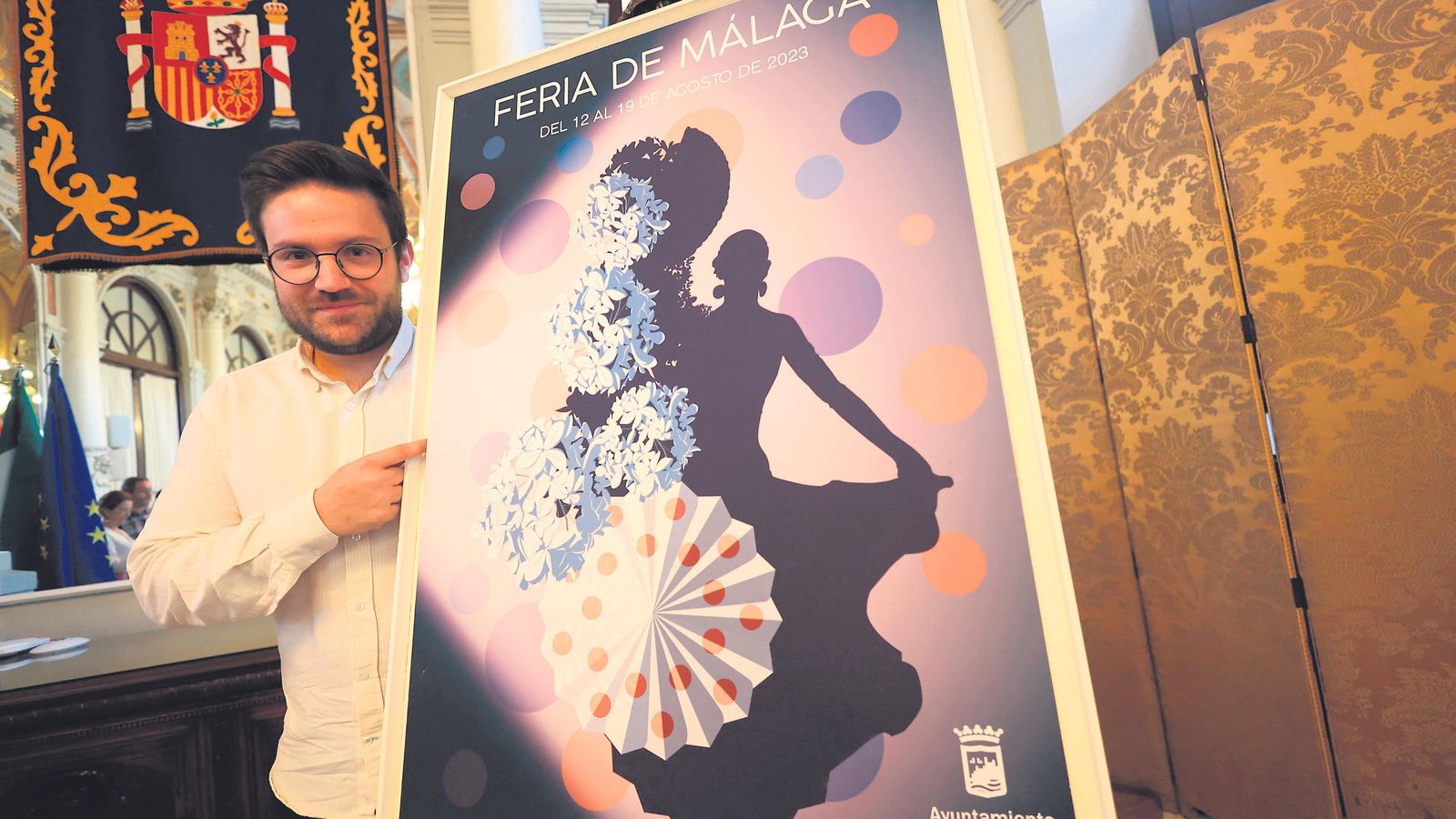 José Carlos Moriel junto al cartel que diseñó para la Feria de Málaga 2023