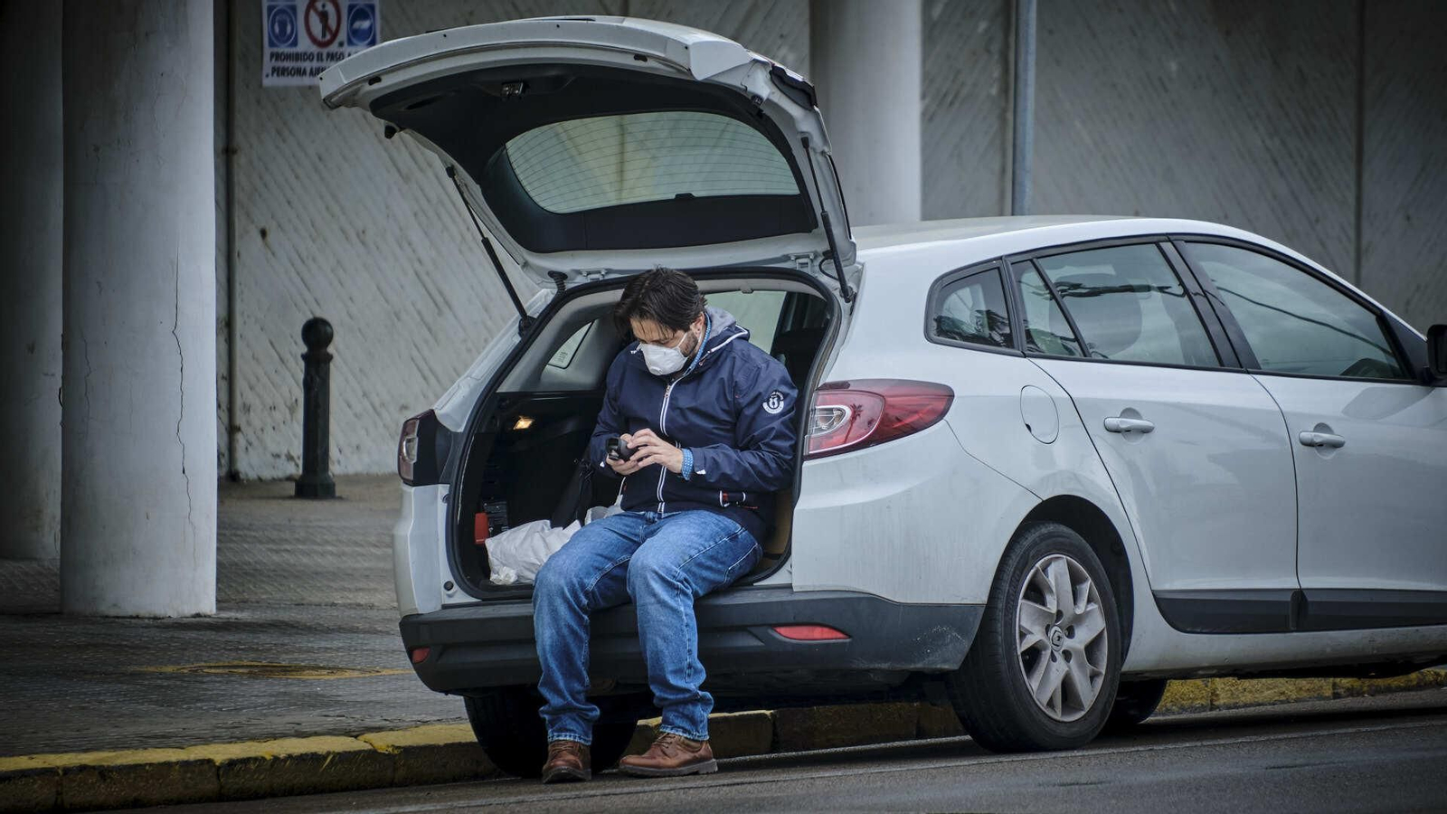 Un hombre sentado en la parte trasera de su coche junto a Tiempo Libre
