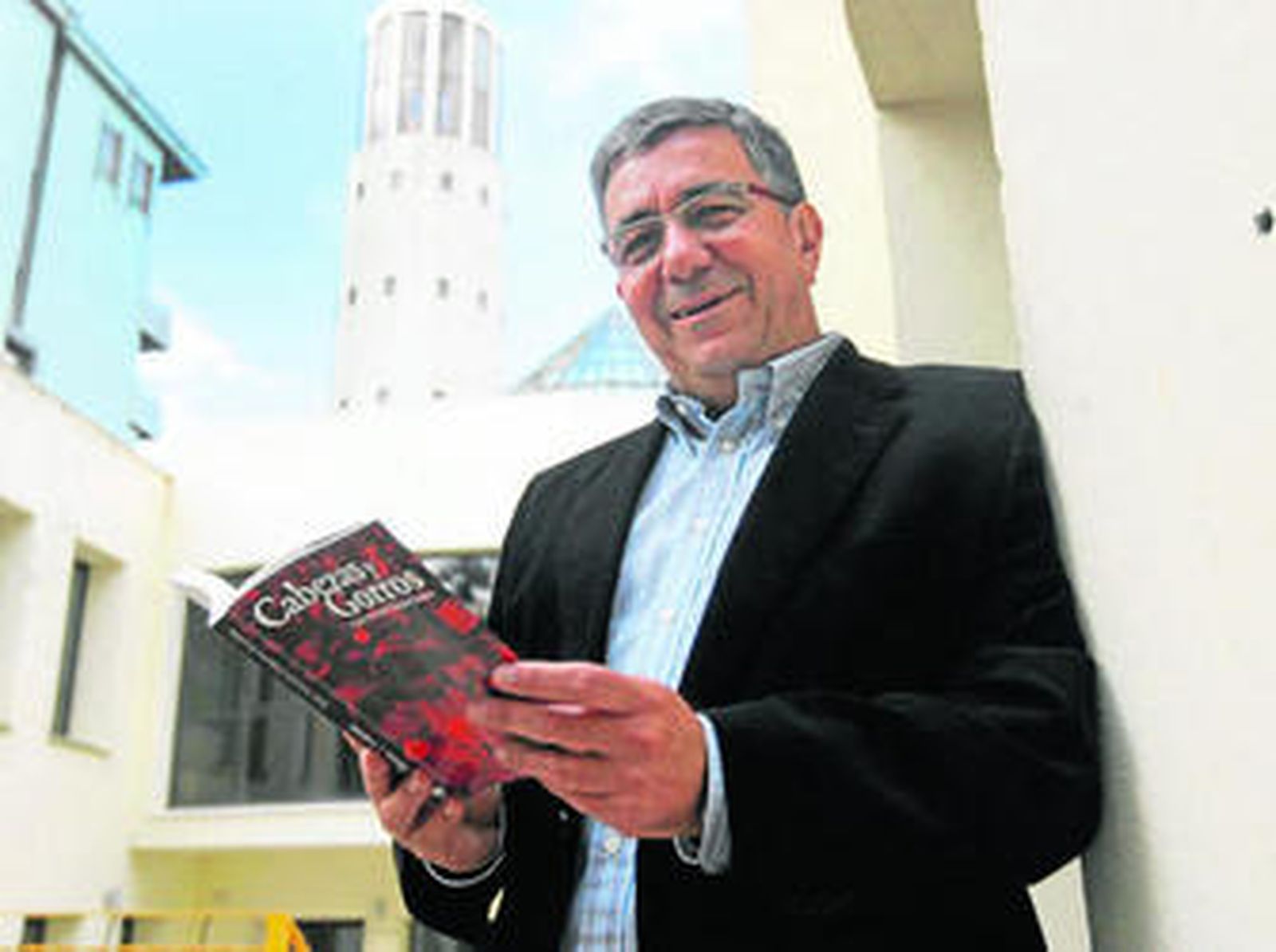 Imagen de Juan Antonio Palacios con el único ejemplar qeu posee en mano de su tercer libro 'Cabezas y gorros'.