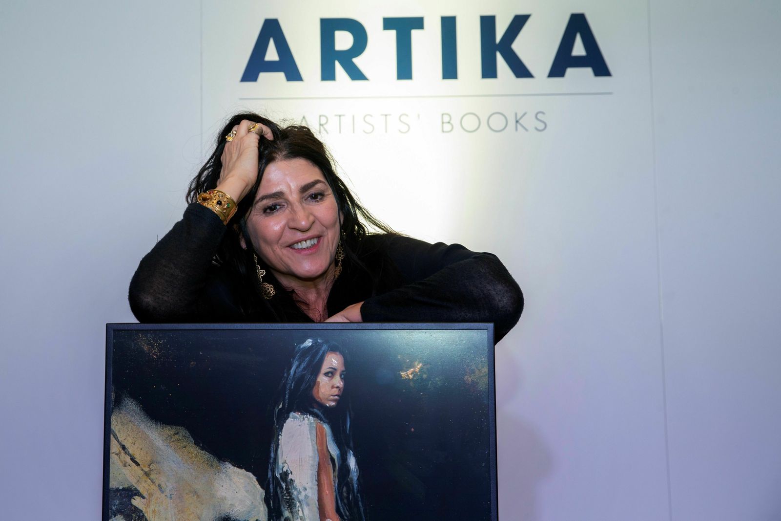 La artista Lita Cabellut posa junto a una de las obras del libro.