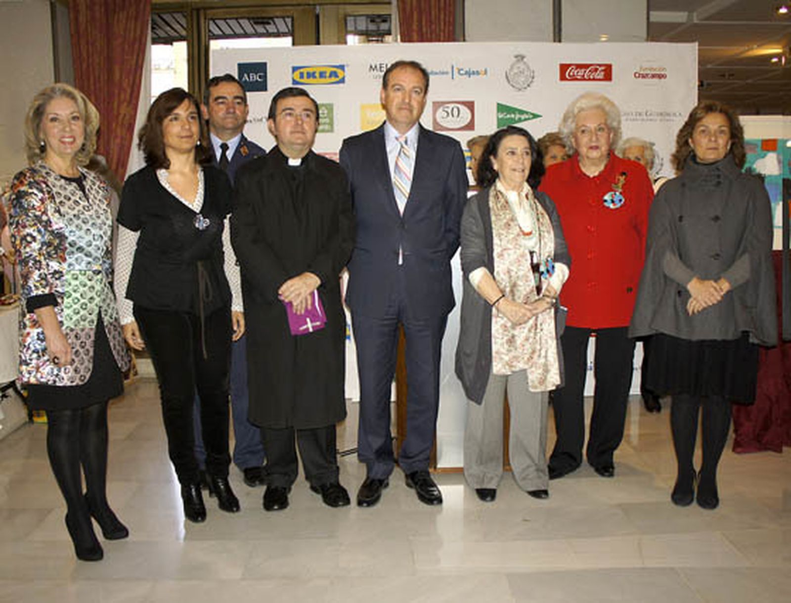 María Gómez Galván (Obra Social Cajasol), Mercedes Camacho (Fundación Cajasol), el director de Enseñanza, general de División Pablo Gómez Rojo; el párroco de la Concepción Inmaculada, Ángel Sánchez, que bendijo el Rastrillo; Alfonso López, director del Hotal Meliá Los Lebreros; María Pepa de la Serna y la infanta Pilar de Borbón, presidenta en Sevilla y presidenta de honor, respectivamente, de Nuevo Futuro, y Lola de Pablo-Blanco, delegada de Asuntos Sociales del Ayuntamiento de Sevilla.   Foto: Victoria Ramírez