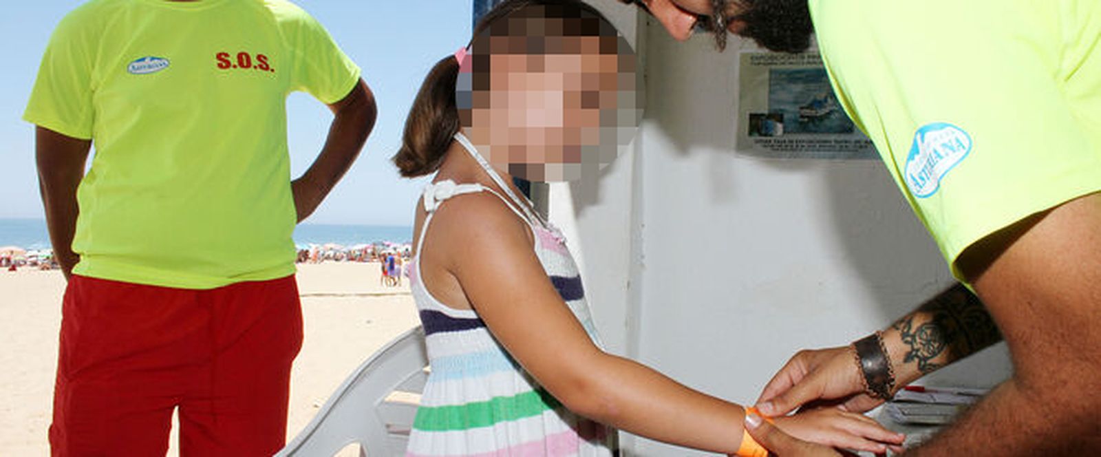 Voluntarios de Cruz Roja le colocan una pulsera a una niña en una imagen de archivo.