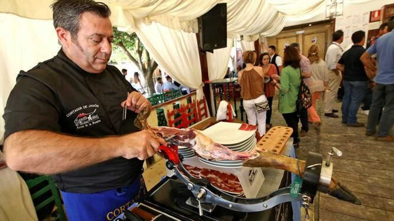Un cortador de jamón en una caseta de la Feria del Caballo