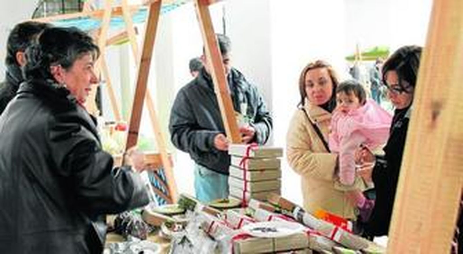 Un grupo de clientes, ante un expositor de hijos ecológicos.