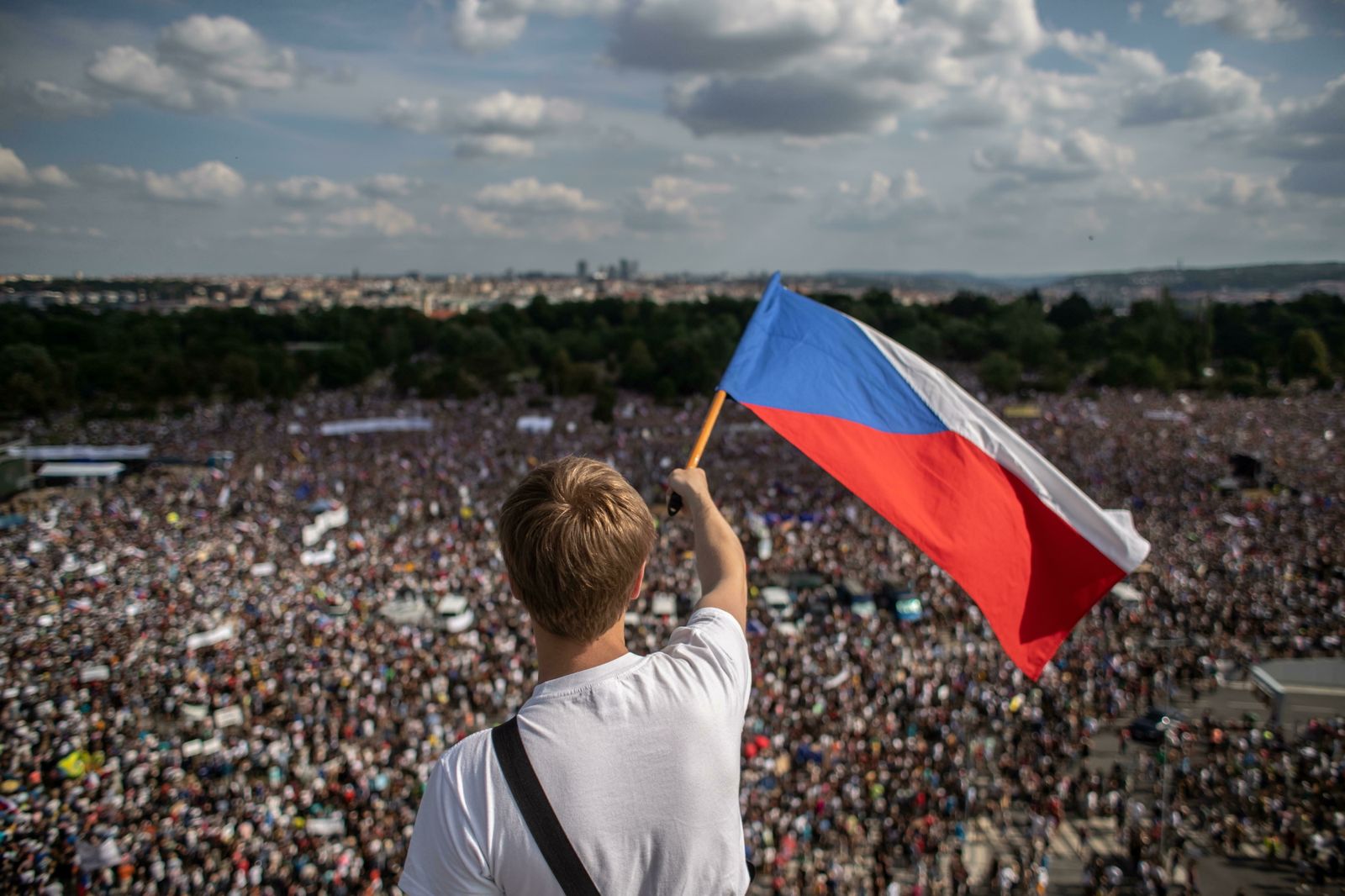 Un checo ondea una bandera mientras observa la multitudinaria protesta en el parque de Letná en Praga.
