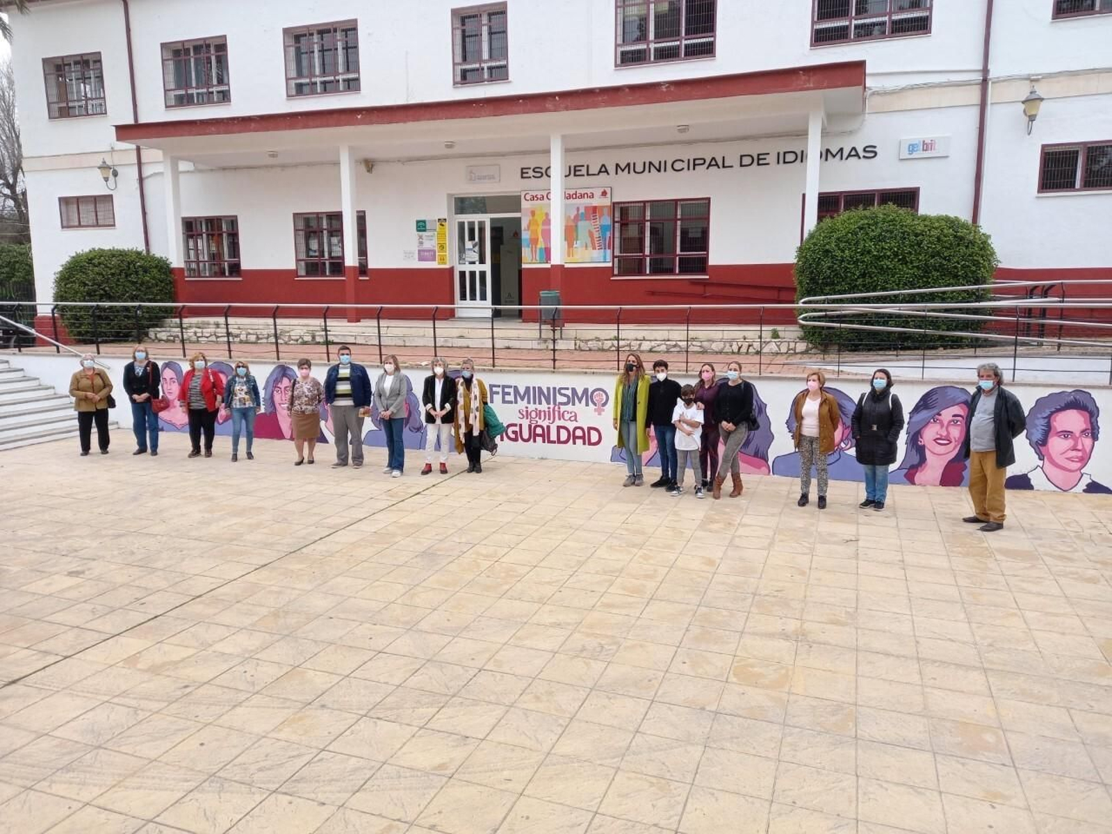 Los asistentes al acto posan delante del mural.