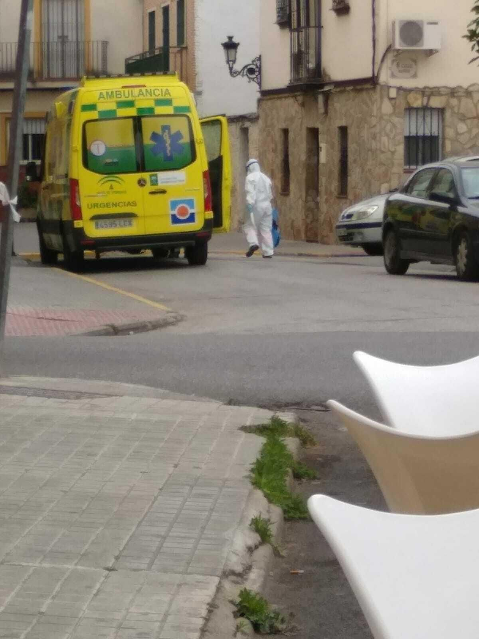 Un profesional sanitario junto a una ambulancia equipado con protección individual.