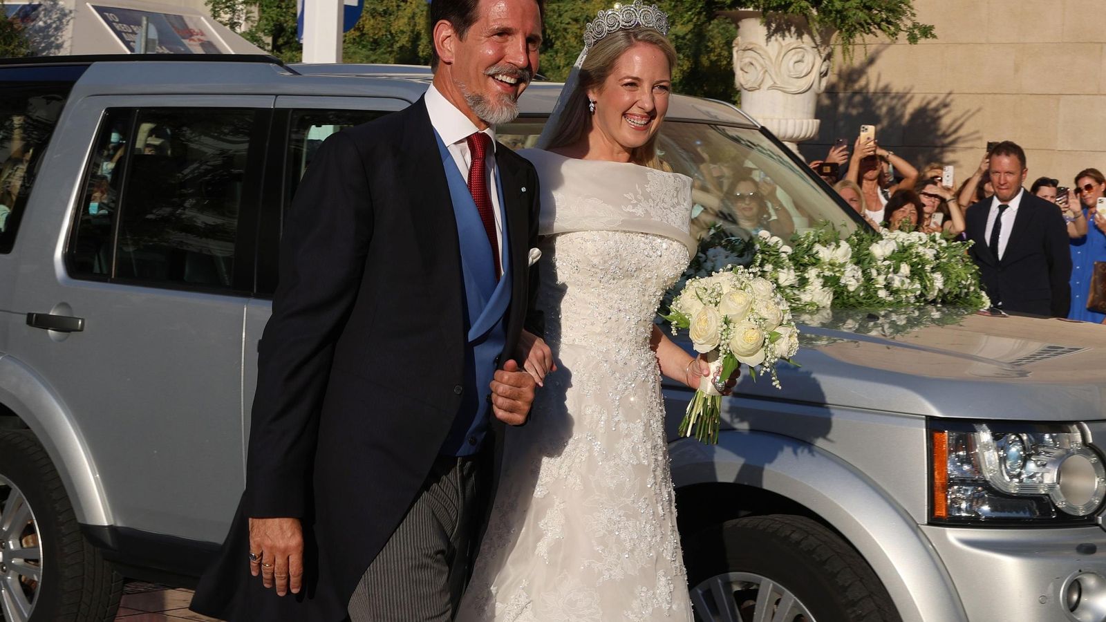 La princesa Teodora, radiante, llega a la catedral de Atenas del brazo de su padrino y hermano, el príncipe Pablo