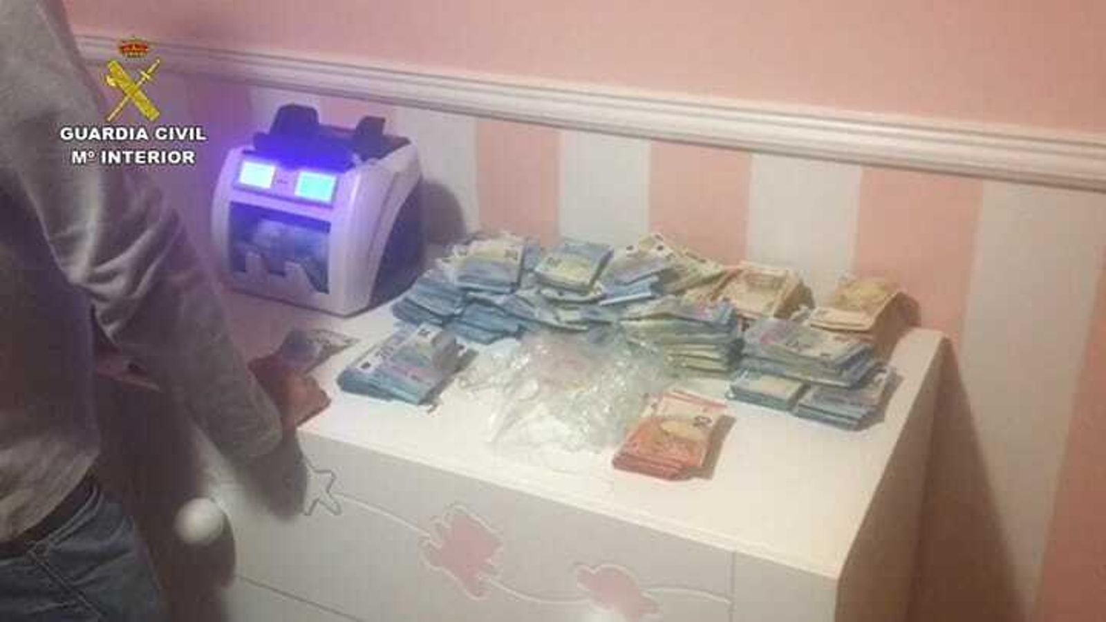 El dinero incautado y la máquina de contar billetes.