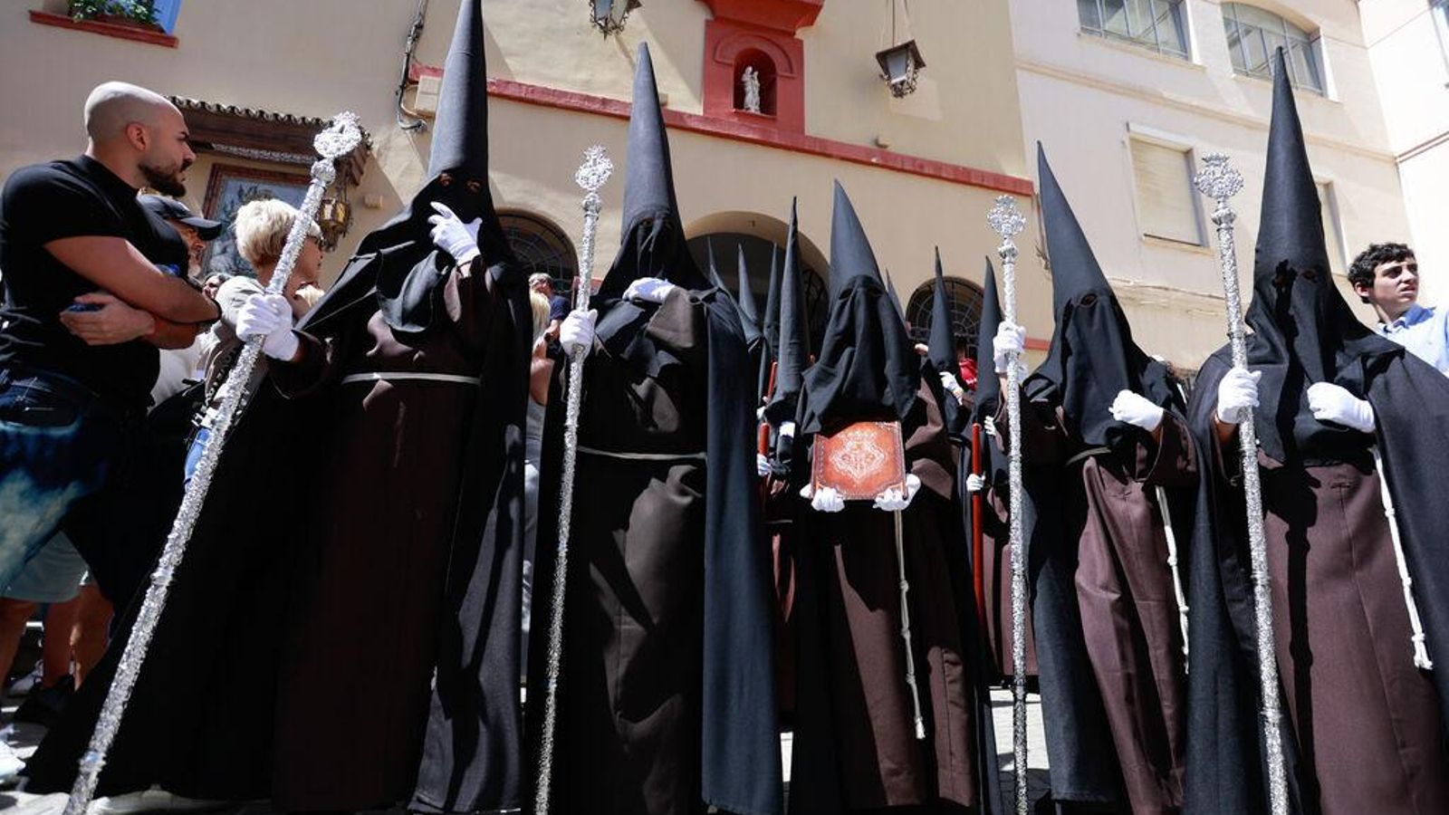 Los nazarenos de túnica marrón, capirote y capa negras inician el recorrido desde la Divina Pastora.