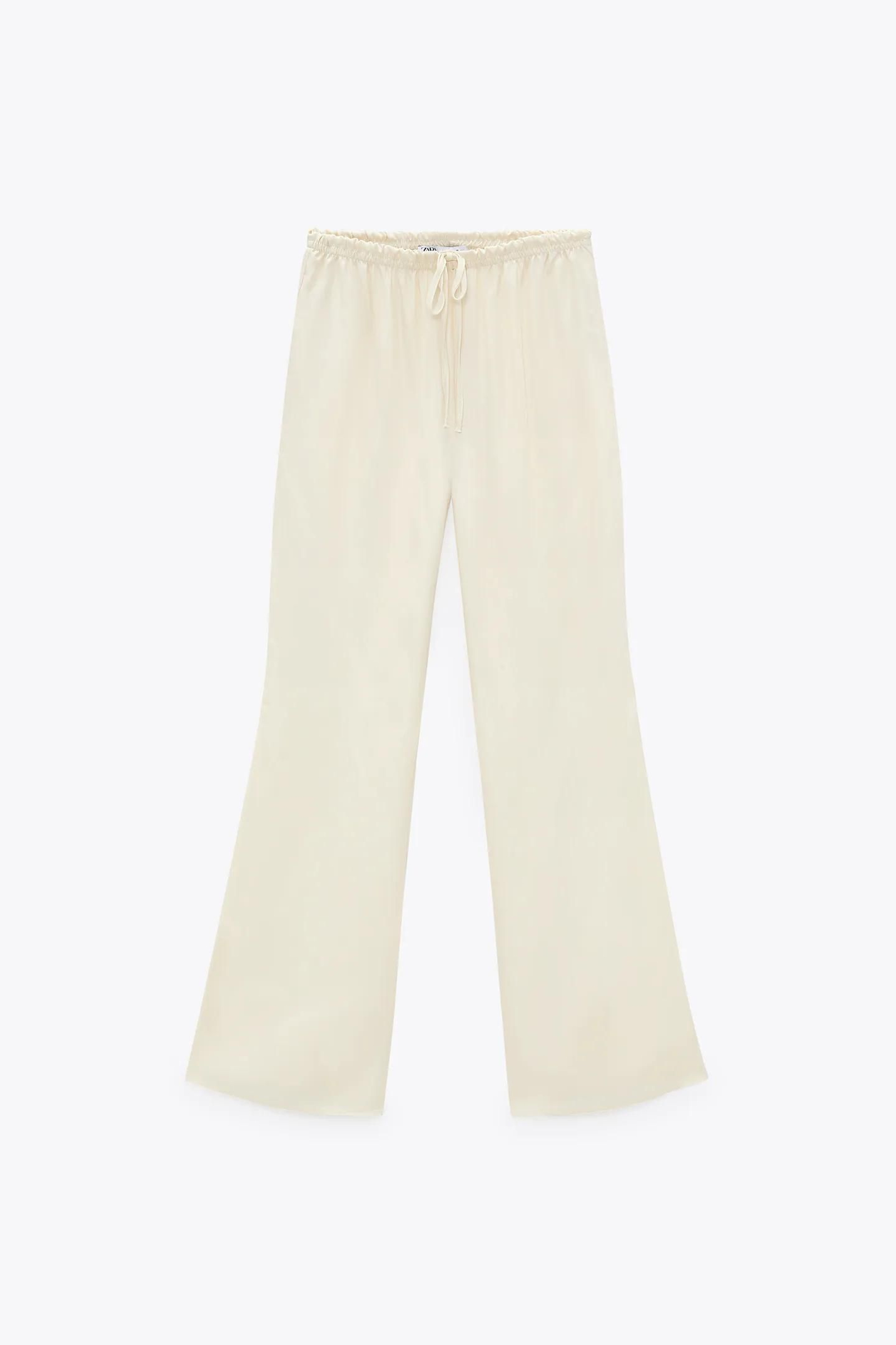 Pantalones campana de Zara en color blanco y satinados.