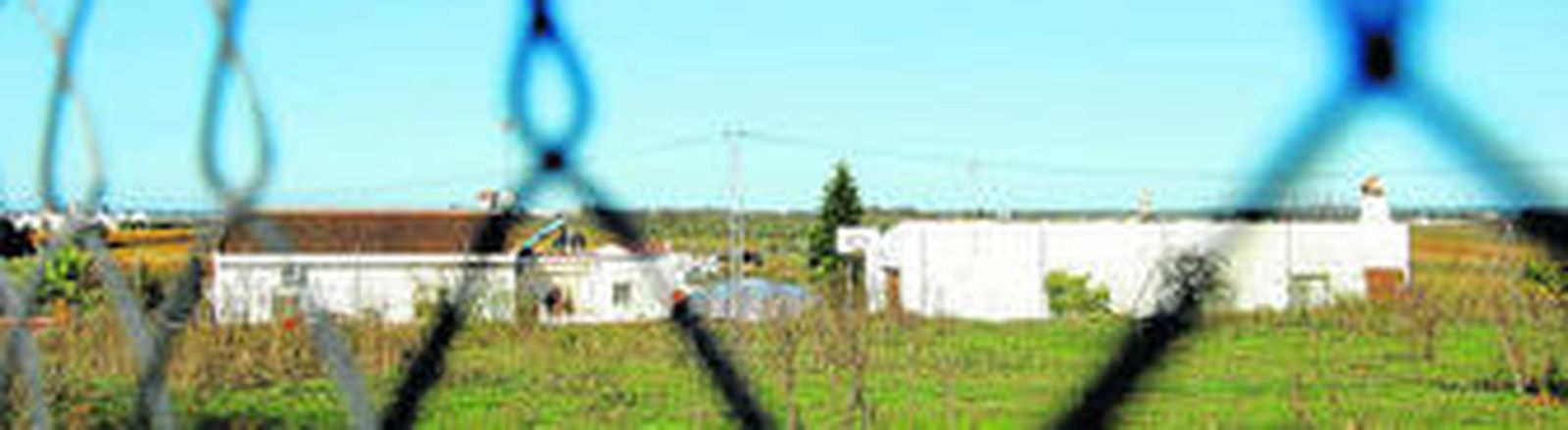 Vista general, desde el exterior de la finca, de la vivienda de Juan Polo -a la izquierda- y del almacén de aperos -a la derecha- en el paraje La Vasca, en el municipio de Cartaya.