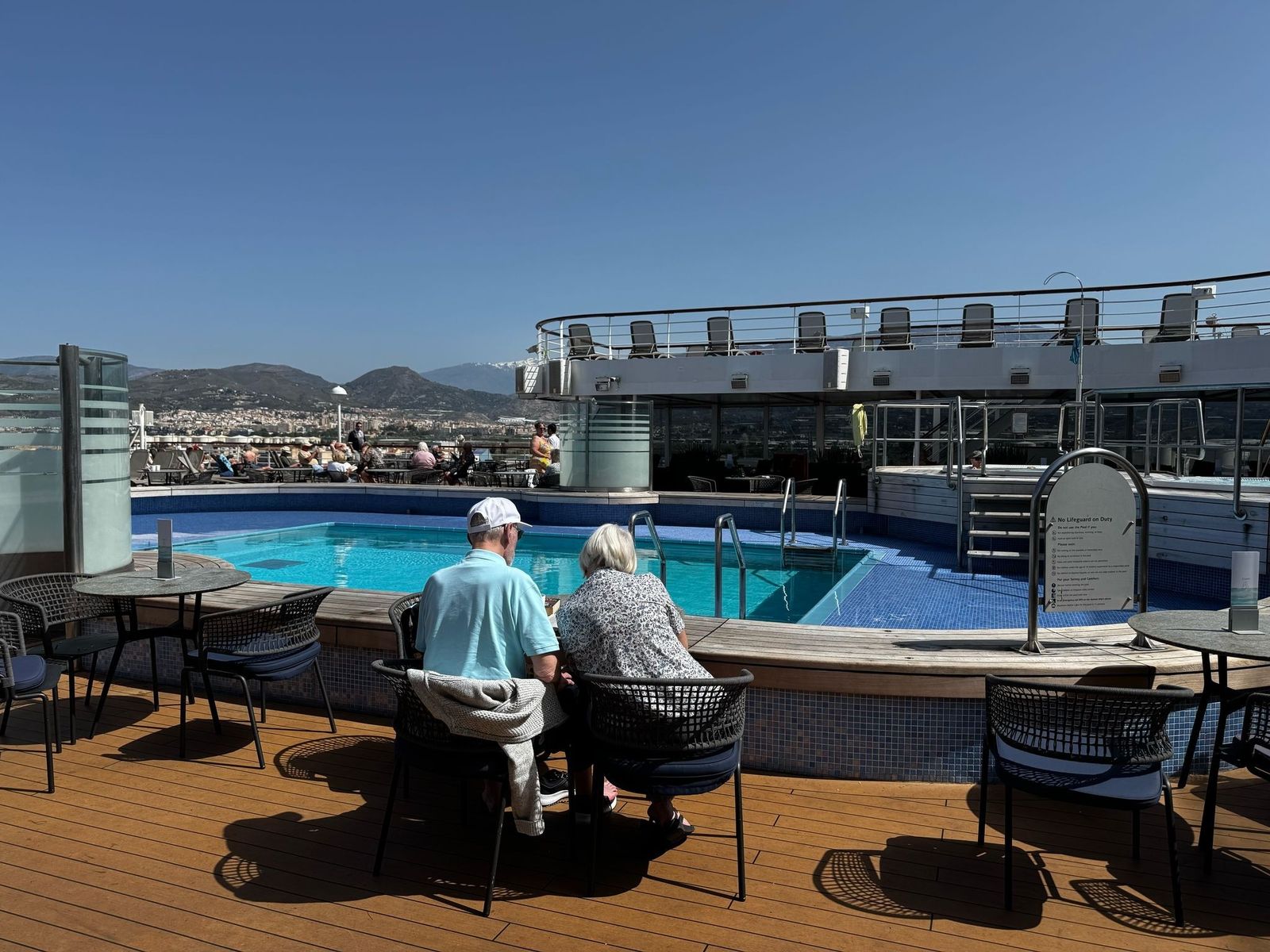 Dos personas pasan la mañana en la cubierta de uno de los cruceros que ha hecho escala en el Puerto de Motril