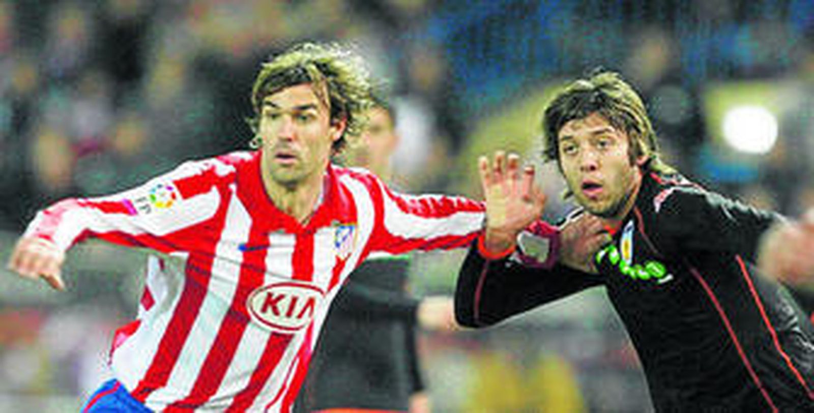 El rojiblanco Valera y el valencianista Dealbert forcejean para ganar la posición a la espera de la llegada del balón.