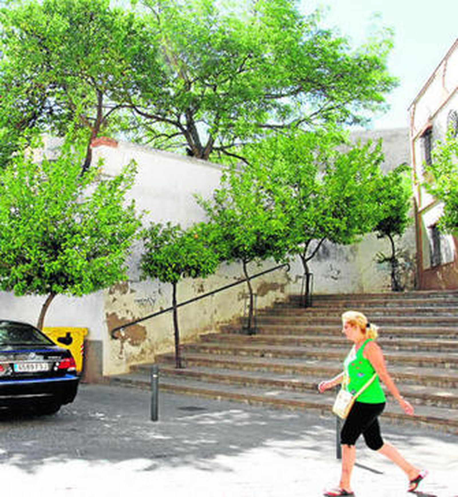 Una mujer pasa por delante de la escalinata de la calle Iglesia.