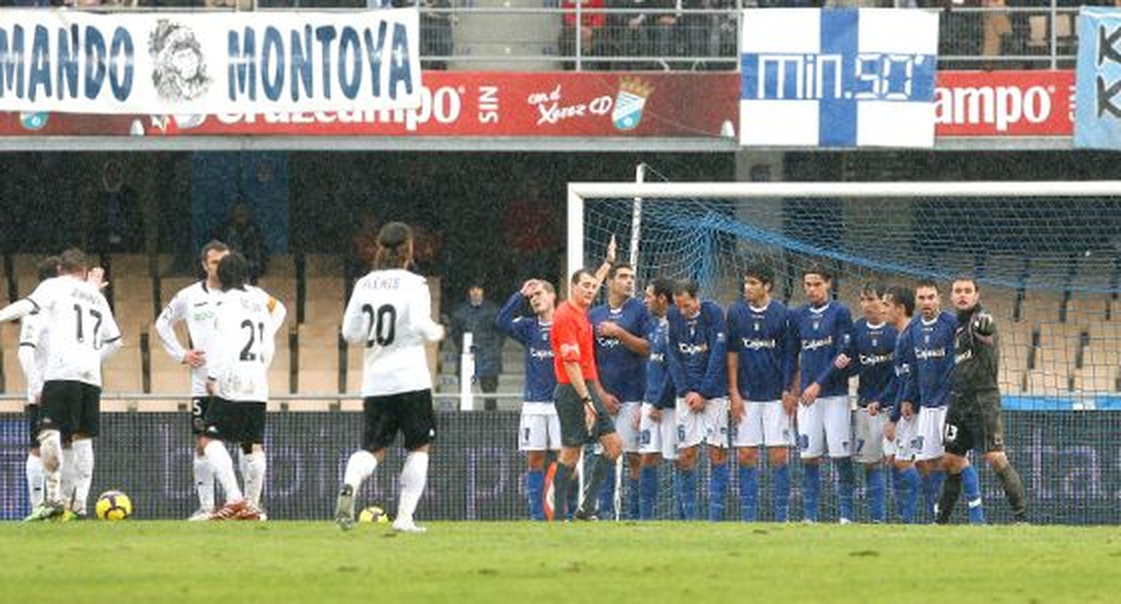 Clos Gómez, muy protestado por su arbitraje en el día de ayer, coloca la barrera de jugadores del Xerez tras señalar una cesión de Bergantiños a Renan que solamente vio él. 

Foto: Pascual