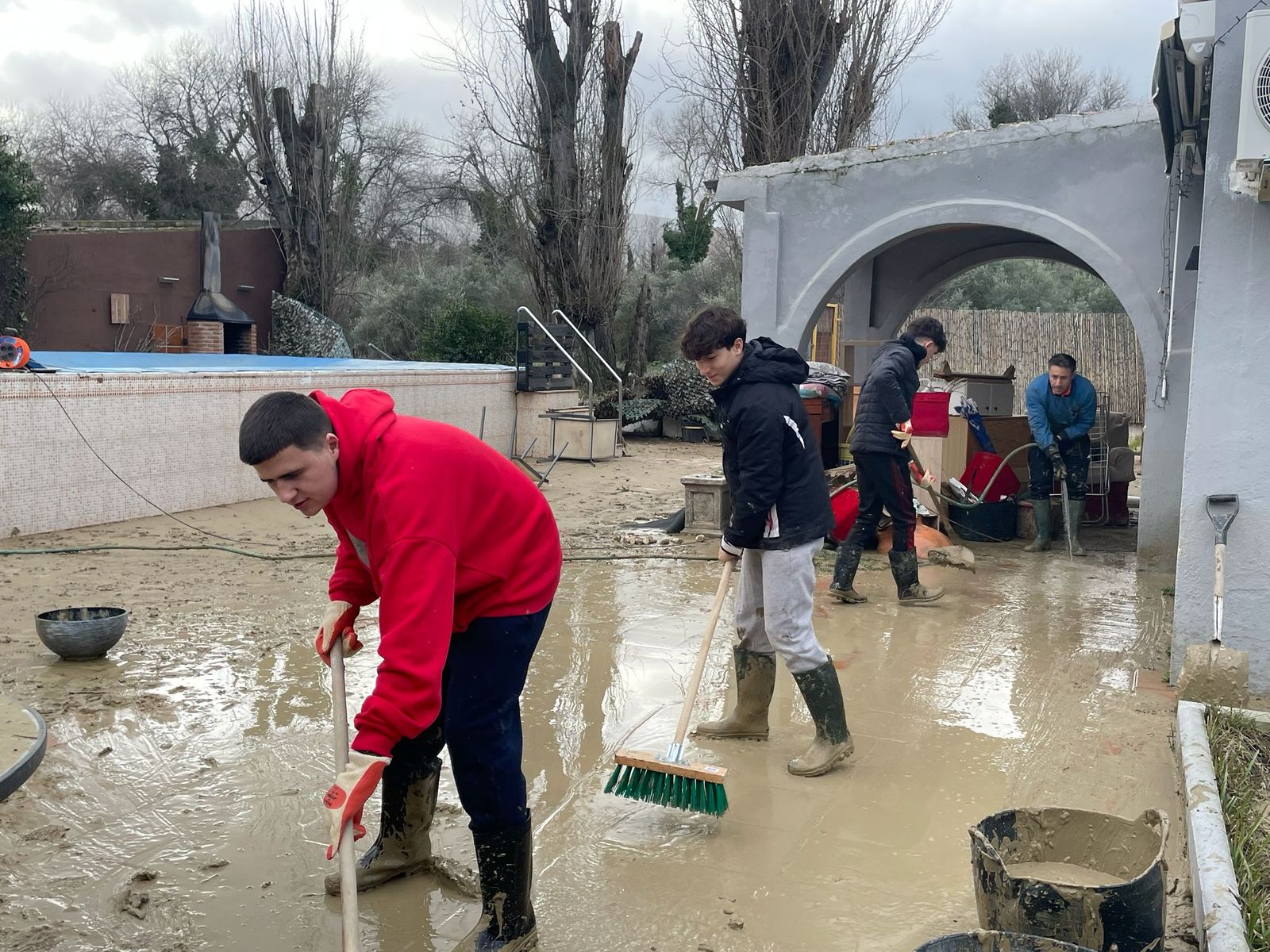 Jóvenes limpiando en una de las casas afectadas de Puente de la Sierra