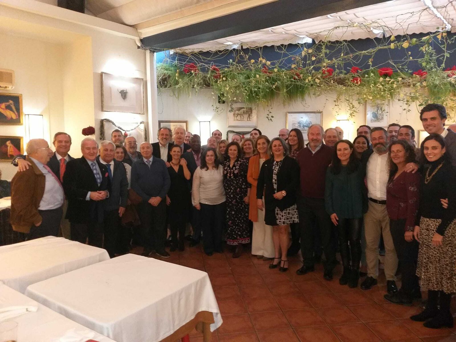 Miembros de la asociación, con dos de los Reyes de este año, sus chambelanes y el concejal de Fiestas, en el Bar Juanito.