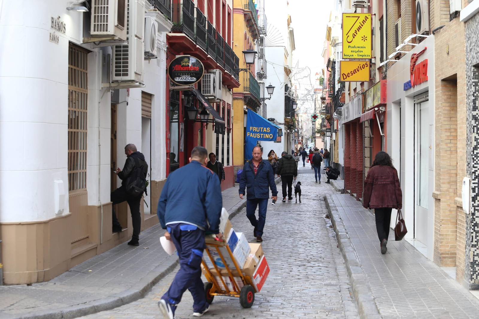 Varios peatones caminan por la calzada y las aceras del tramo de Baños más cercano a la Plaza de la Gavidia.