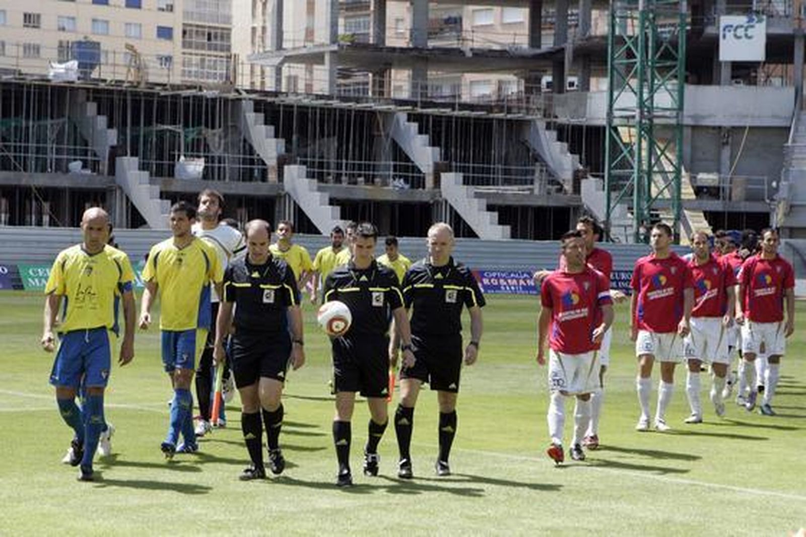 Cádiz y Roquetas saltan al terreno de juego junto al trío arbitral.  Foto: Jesus Marin