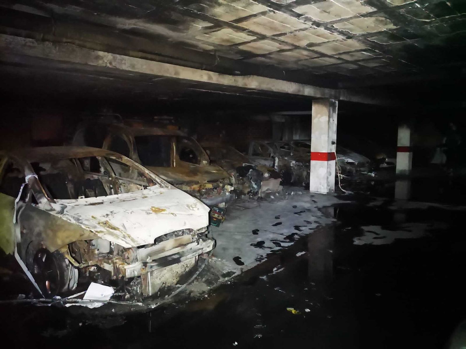 Estado de los vehículos tras el incendio en el garaje.