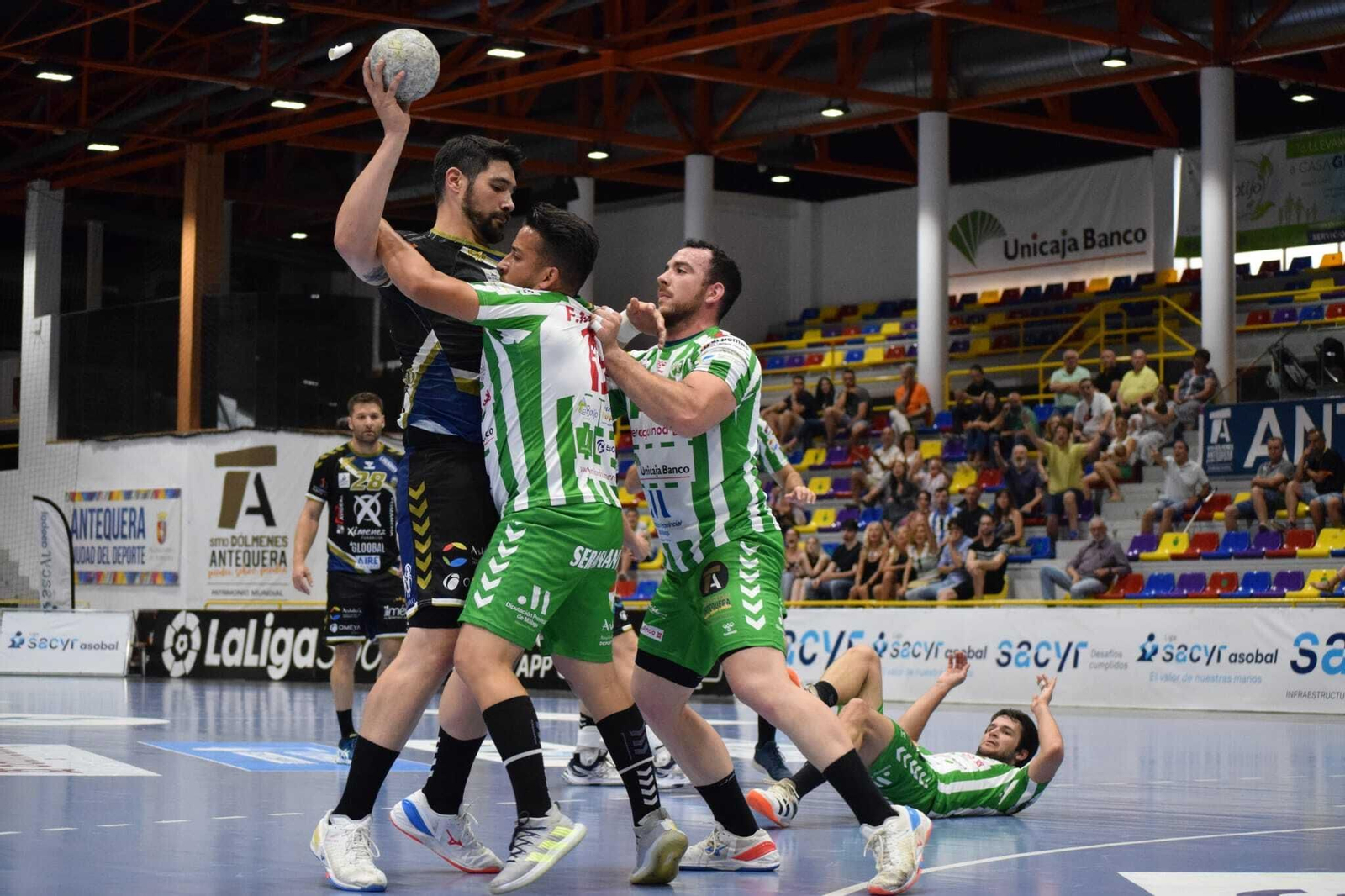 Javi García recibe la defensa de dos jugadores del Antequera.