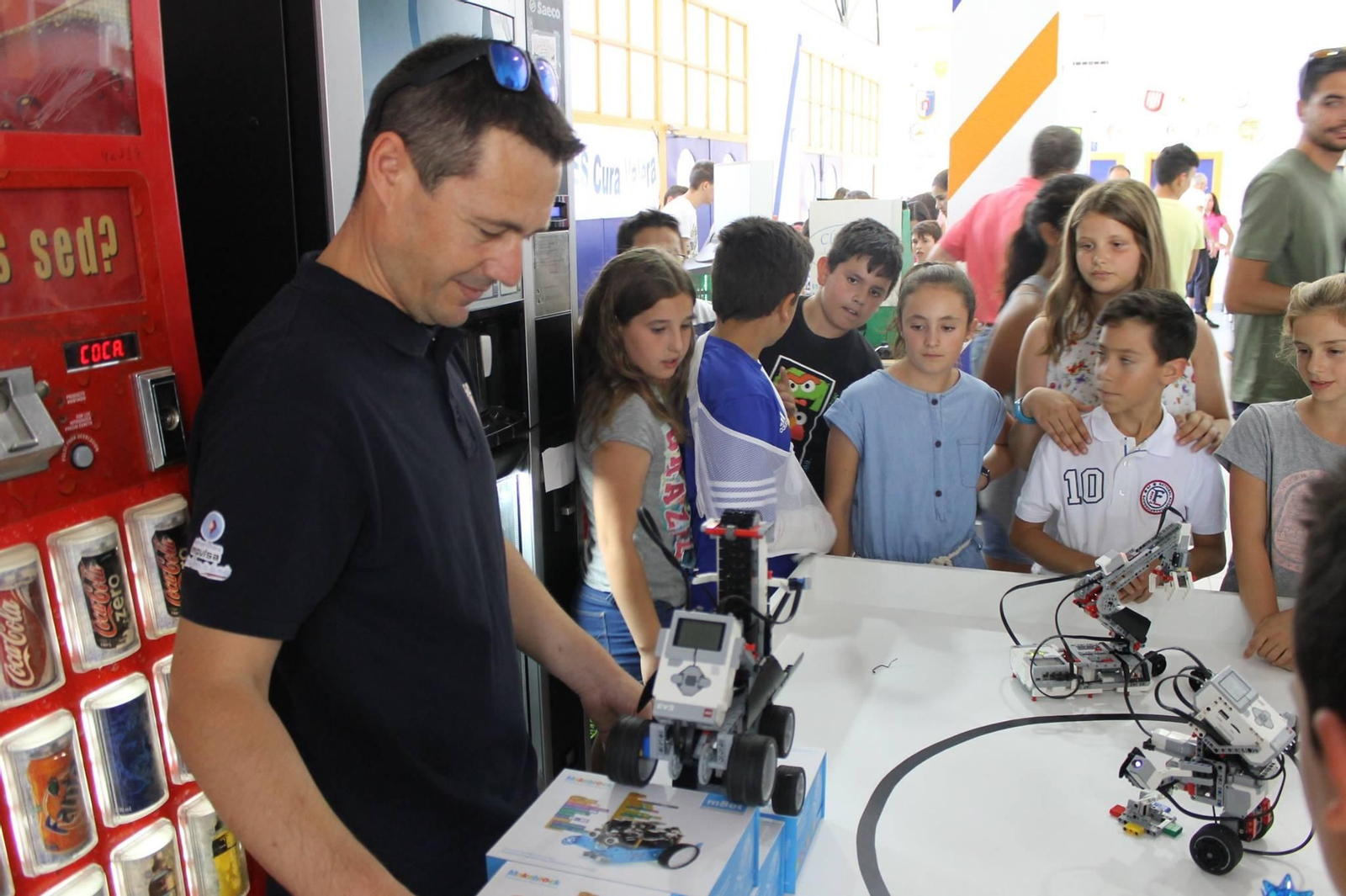 Alumnos y alumnas observan el funcionamiento de un robot.