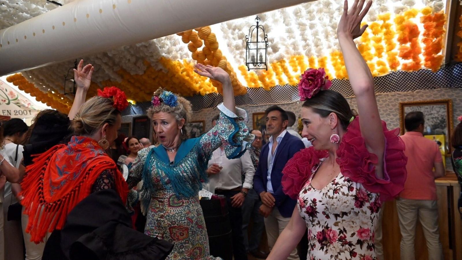 Unas mujeres bailan en una de las casetas.