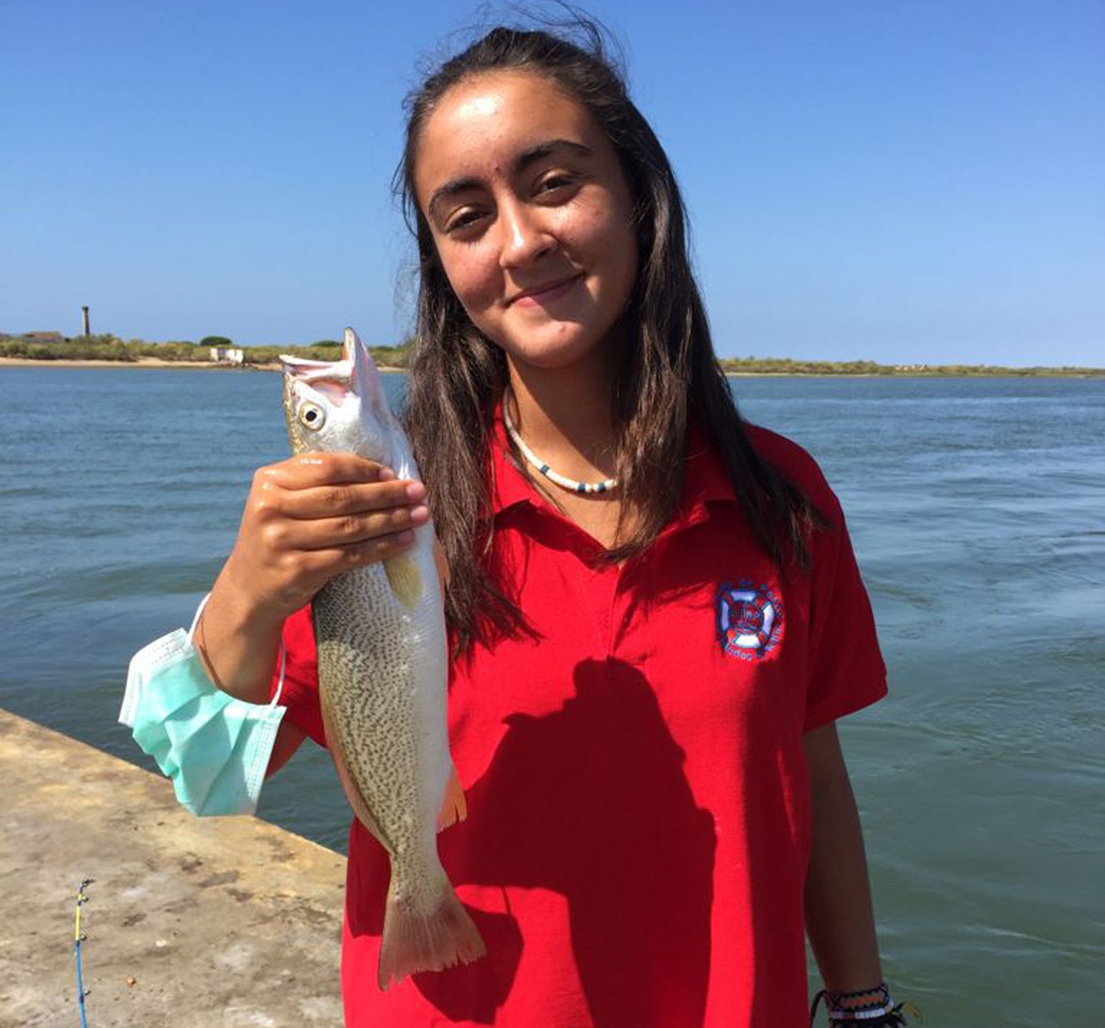 Una de las alumnas de la Escuela de pesca muestra uno de los ejemplares capturados
