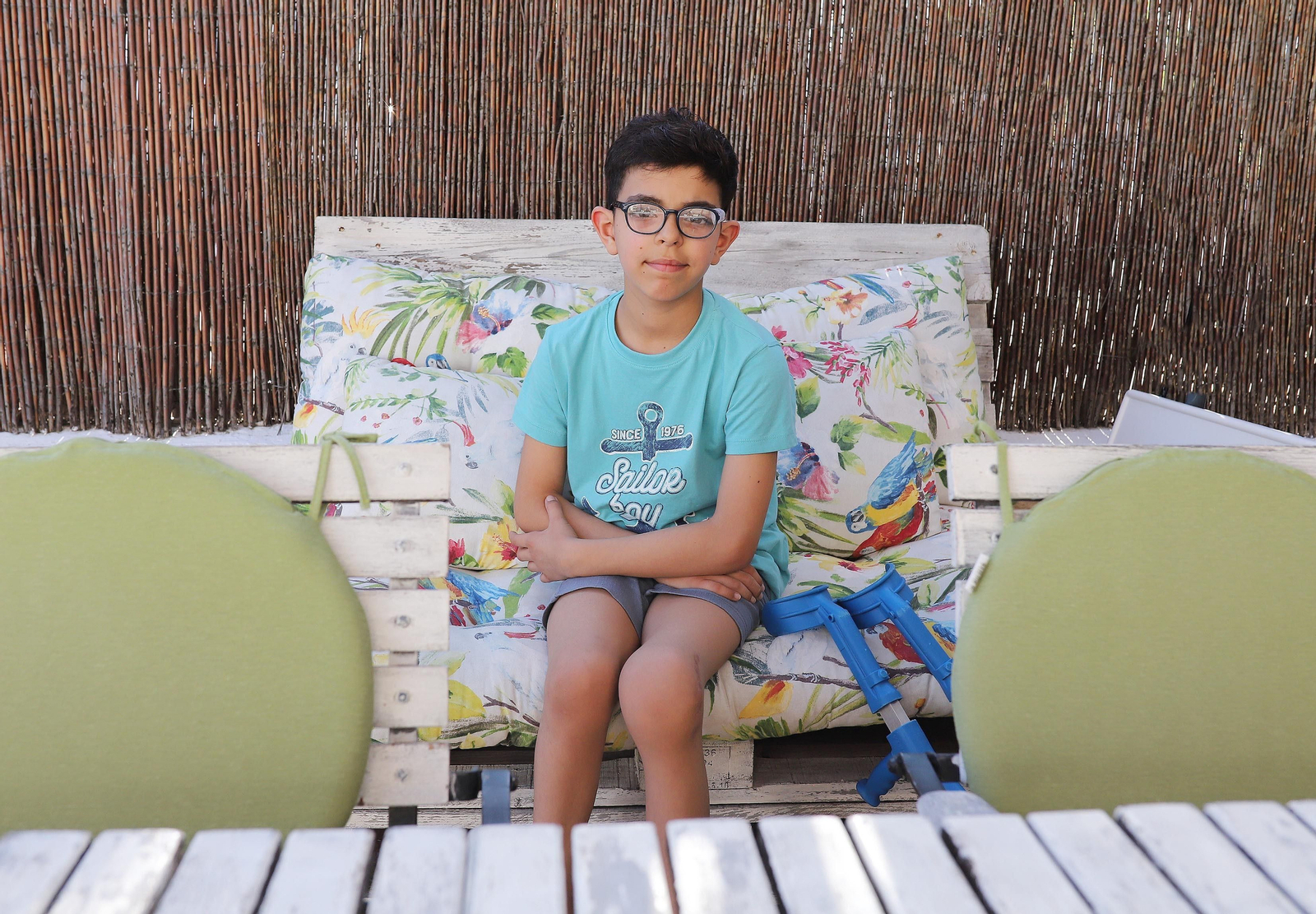 Hugo posa en su casa y es visible la rodilla que tiene deformada por los tumores y el absceso.