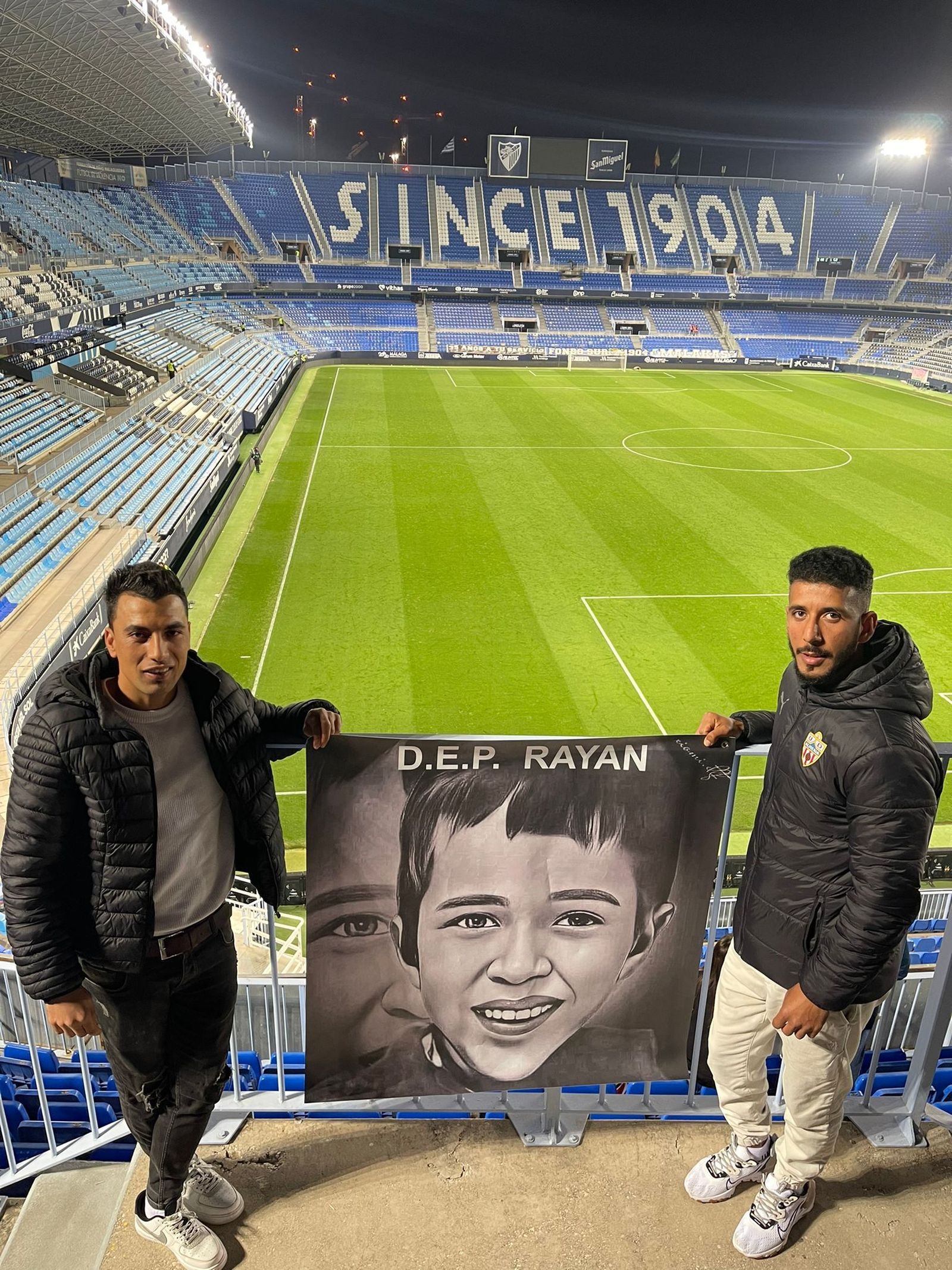 Dos miembros de la Peña Milhojas con la pancarta.