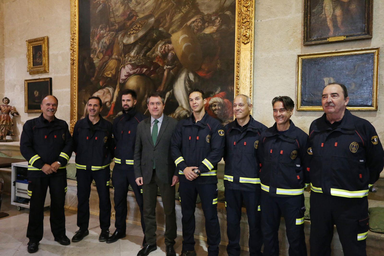 El alcalde, Juan Espadas, posa junto a los bomberos,  en el Ayuntamiento de Sevilla.