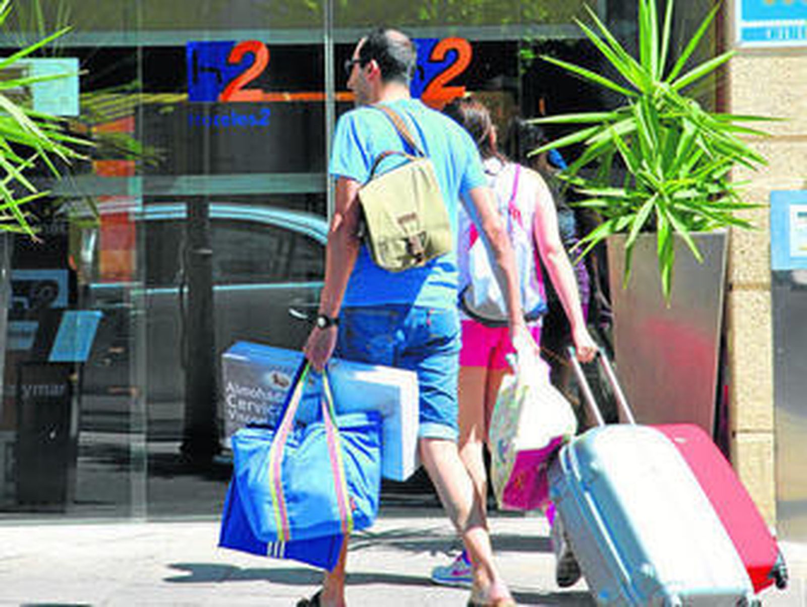 Clientes de un hotel, a la entrada del establecimiento con las maletas, en una imagen de archivo.