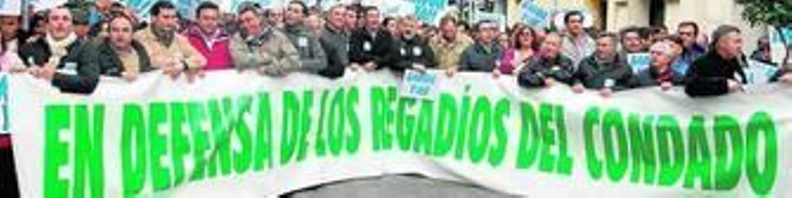 1. Cientos de manifestantes gritan portando pancartas reivindicativas al inicio de la marcha. 2. Cristóbal Picón, presidente de la Plataforma en Defensa de los Regadíos, durante la lectura del manifiesto. 3. Picón entrega el escrito al subdelegado del Gobierno, Enrique Pérez Viguera. 4. Manifestantes lucen sus carteles de protesta en las inmediaciones del estadio Nuevo Colombino. 5. La marea, a su paso por la sede de Huelva Información. 6. Dos inmigrantes protestan durante un instante del itinerario. 7. Protesta a las puertas de la Subdelegación del Gobierno. 8. Cabecera de la manifestación.