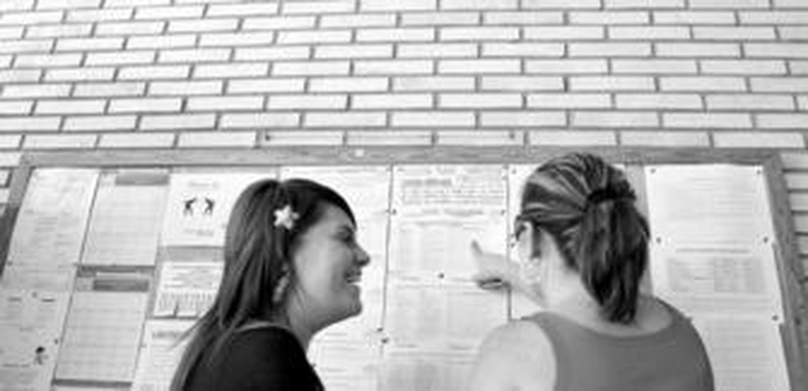 Dos madres miran las listas de admitidos en el colegio Valle Inclán.