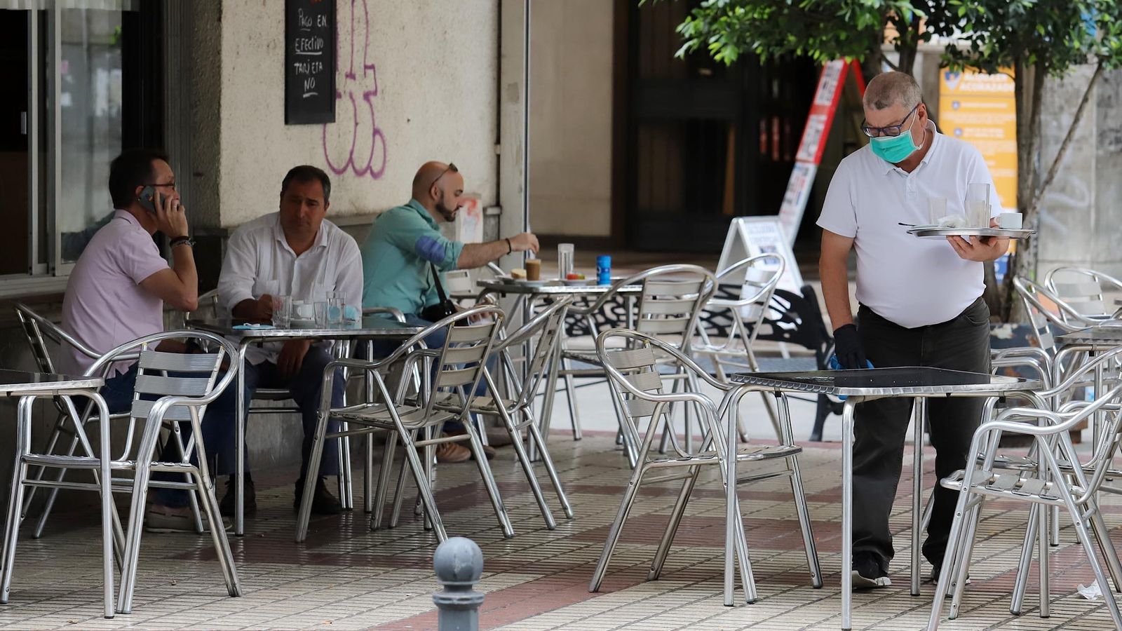 Un camarero desinfecta una mesa de un bar de Huelva.