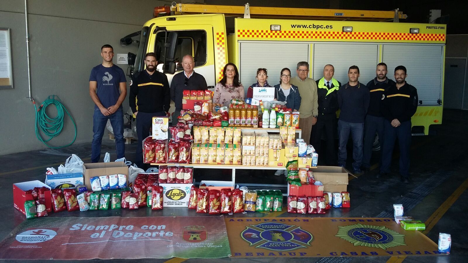 Una representación de Bomberos posa junto a los alimentos recogidos en la última Trail Dos Bahías.