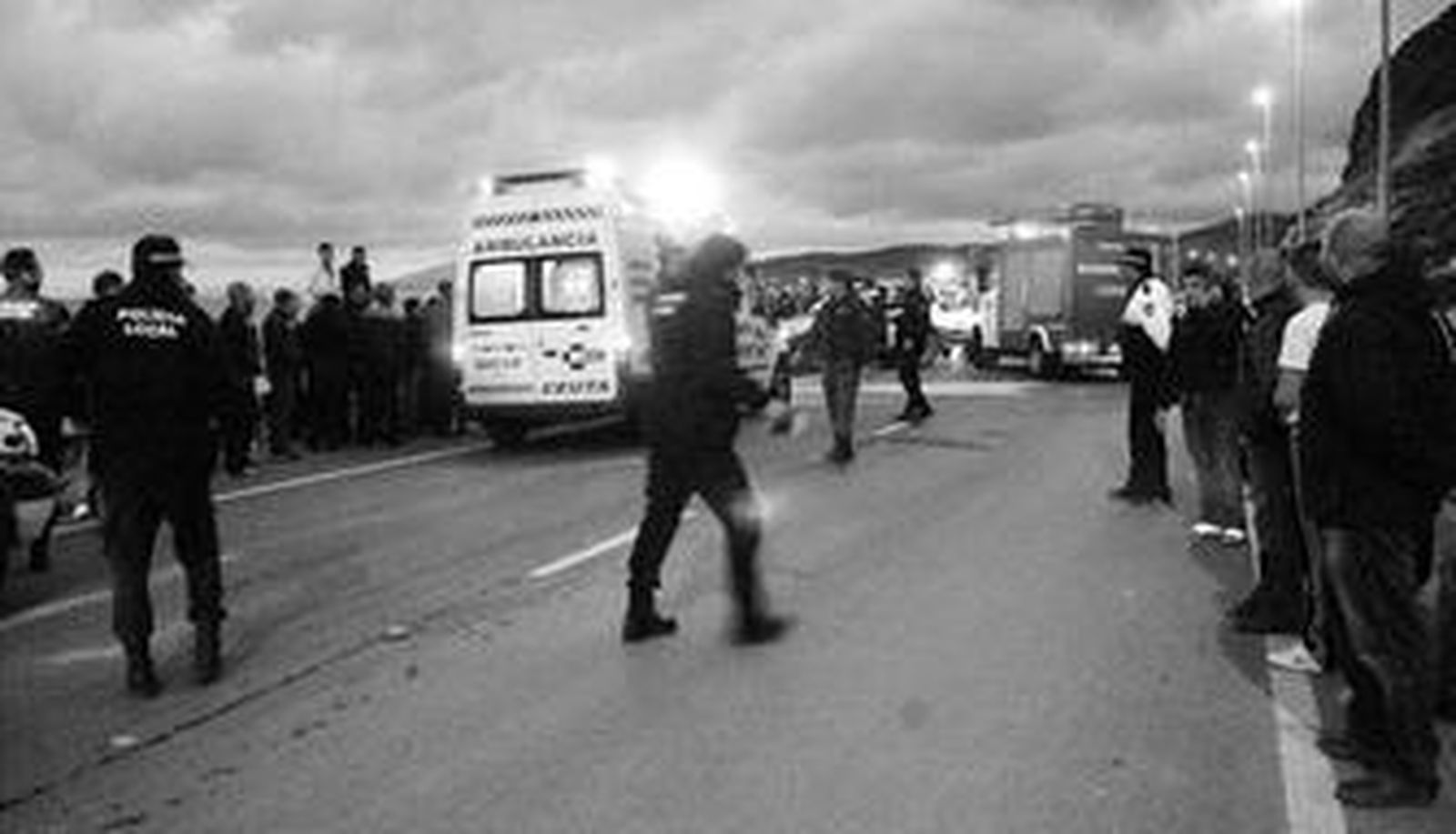 Escenario del accidente. La carretera quedó cortada al tráfico. En el interior de la ambulancia se prestaban los auxilios al joven.