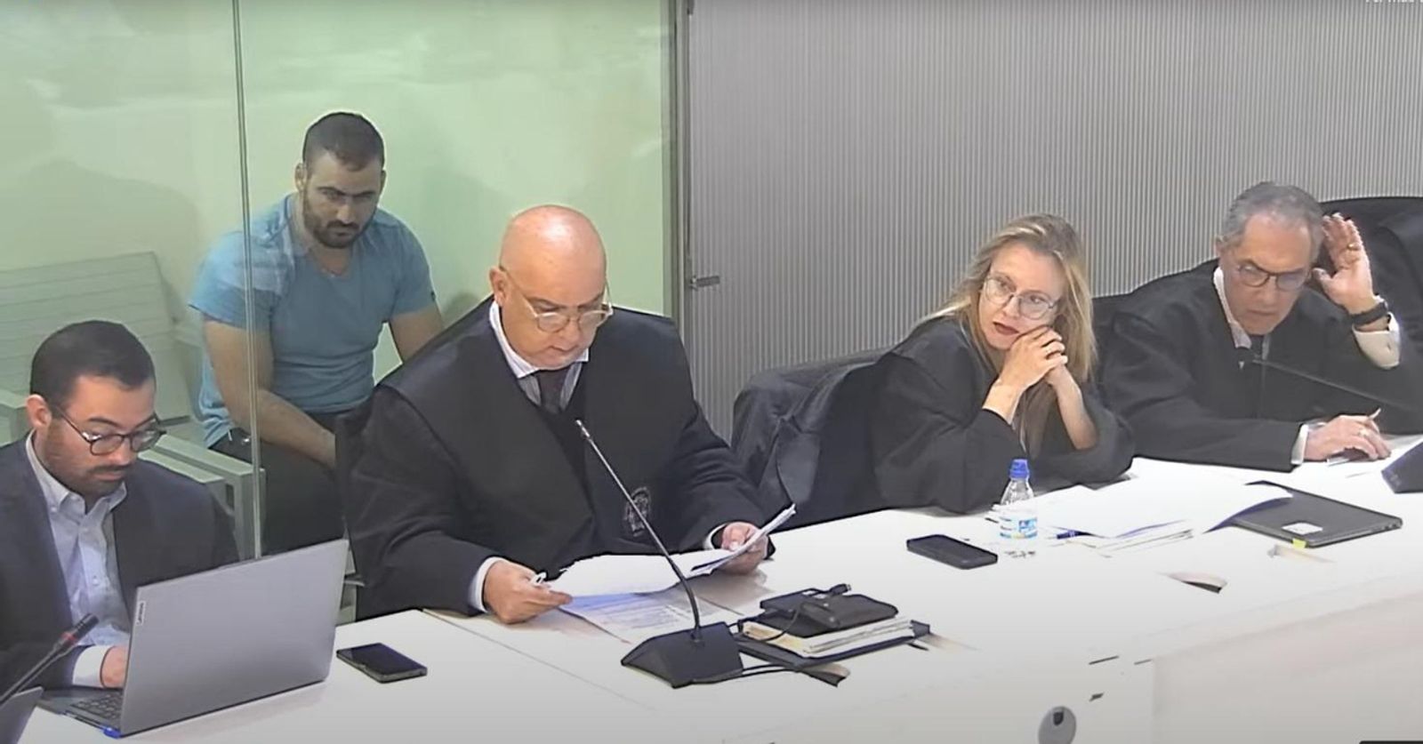 Yasinee Kanjaa asiste al juicio en la celda, con pared de cristal, habilitada en la sala de vistas. En primer término, los abogados de las acusaciones populares.