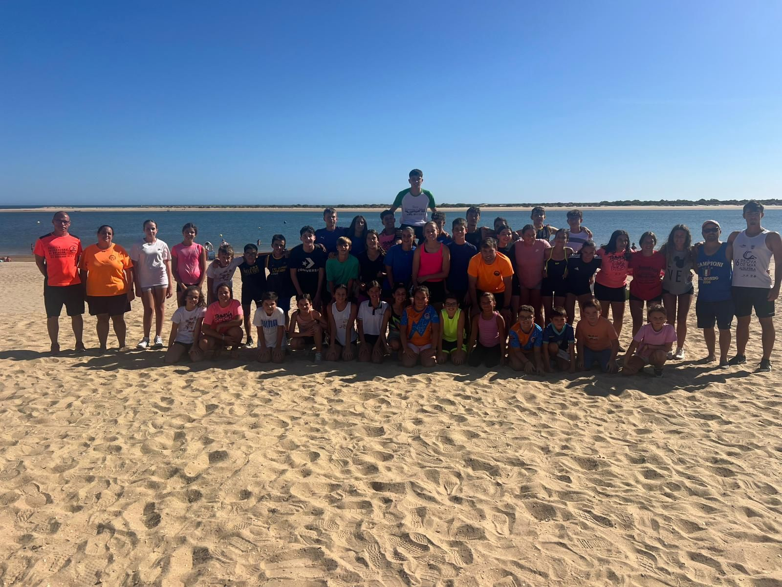 Foto de familia del Club Natación Huelva en la playa del Caño de la Culata.