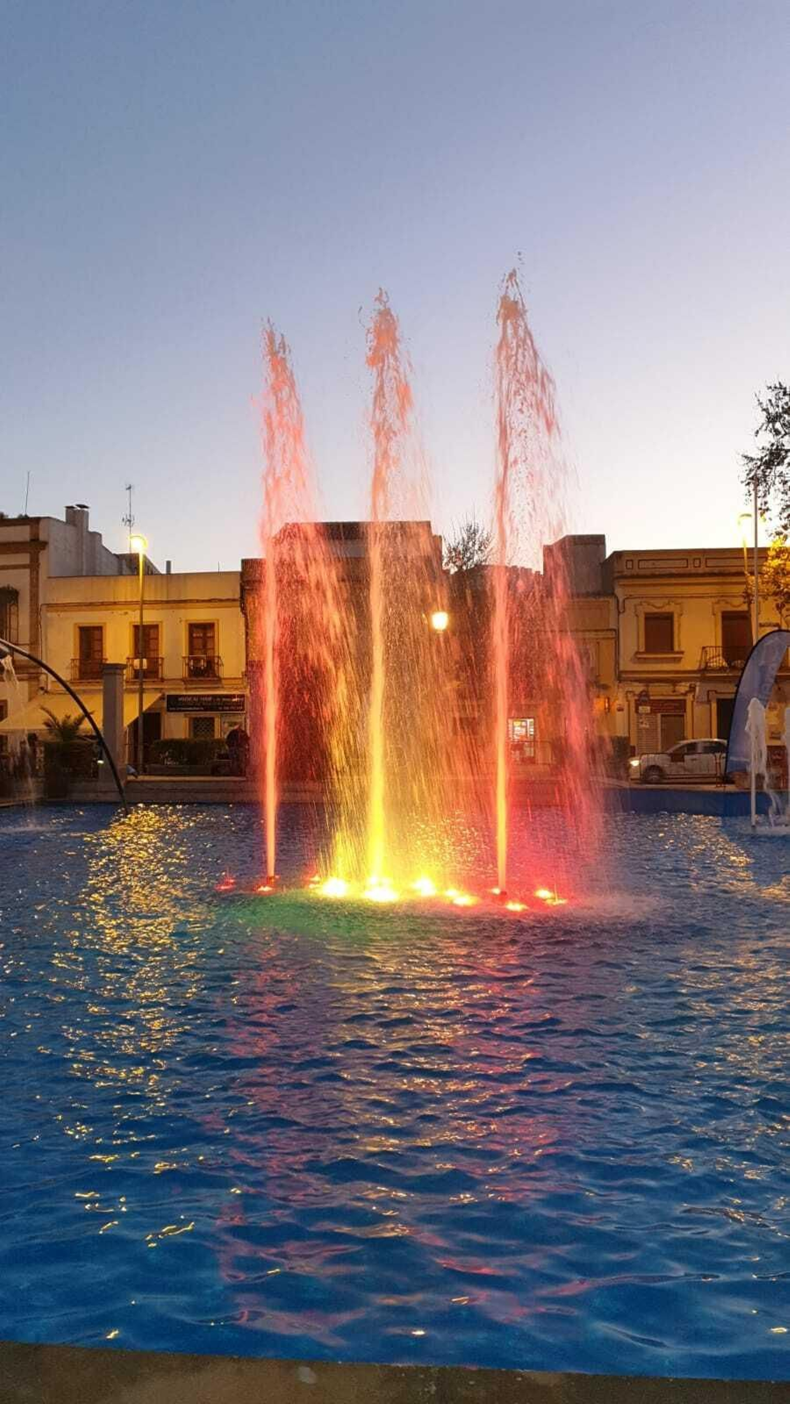 Los chorros de agua de la fuente, iluminados, representaron ayer tarde la bandera de España.
