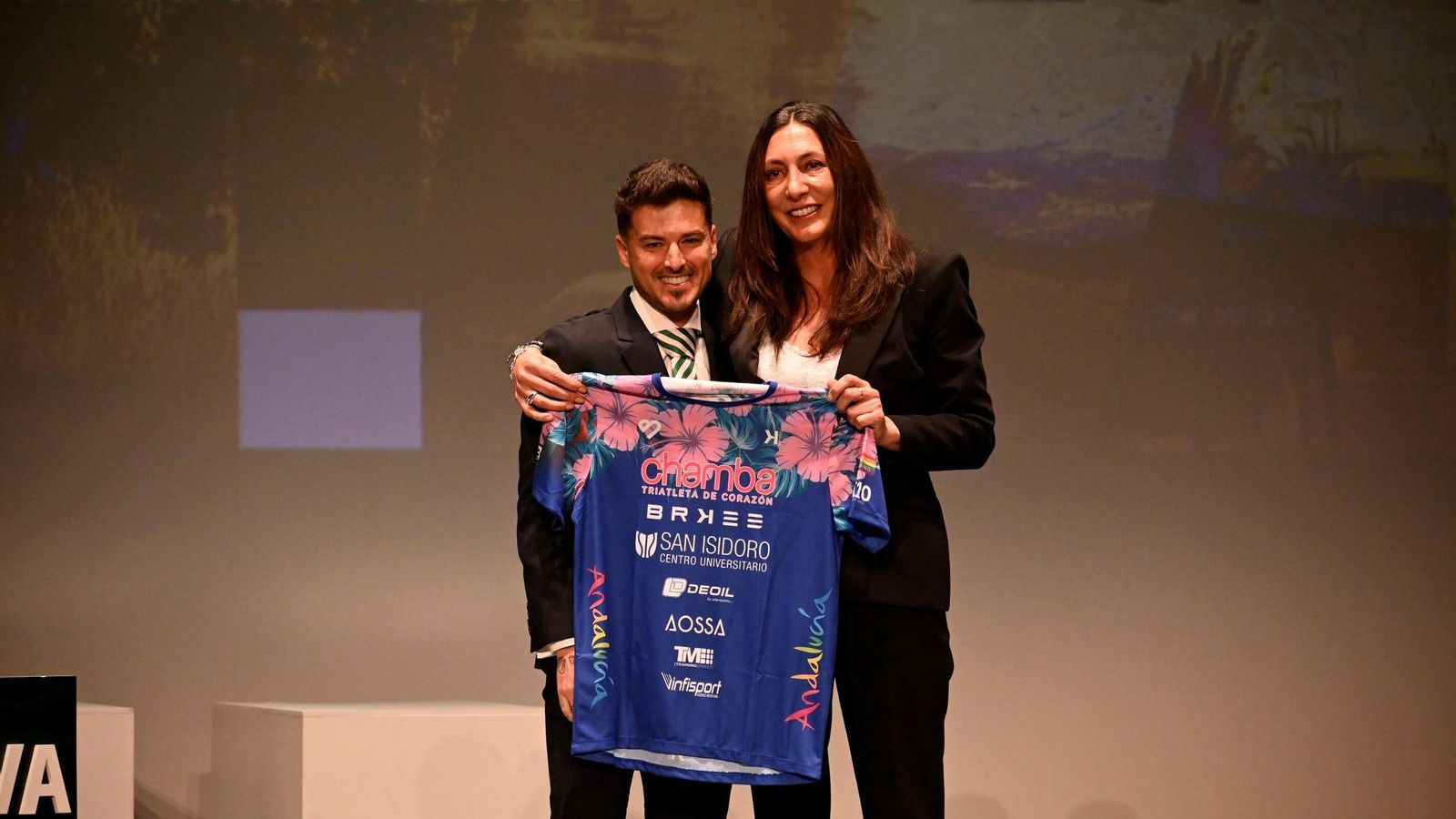 Juan Bautista, 'Chamba', entrega a Loles López la camiseta con la consiguió el Ultramán de Hawai.