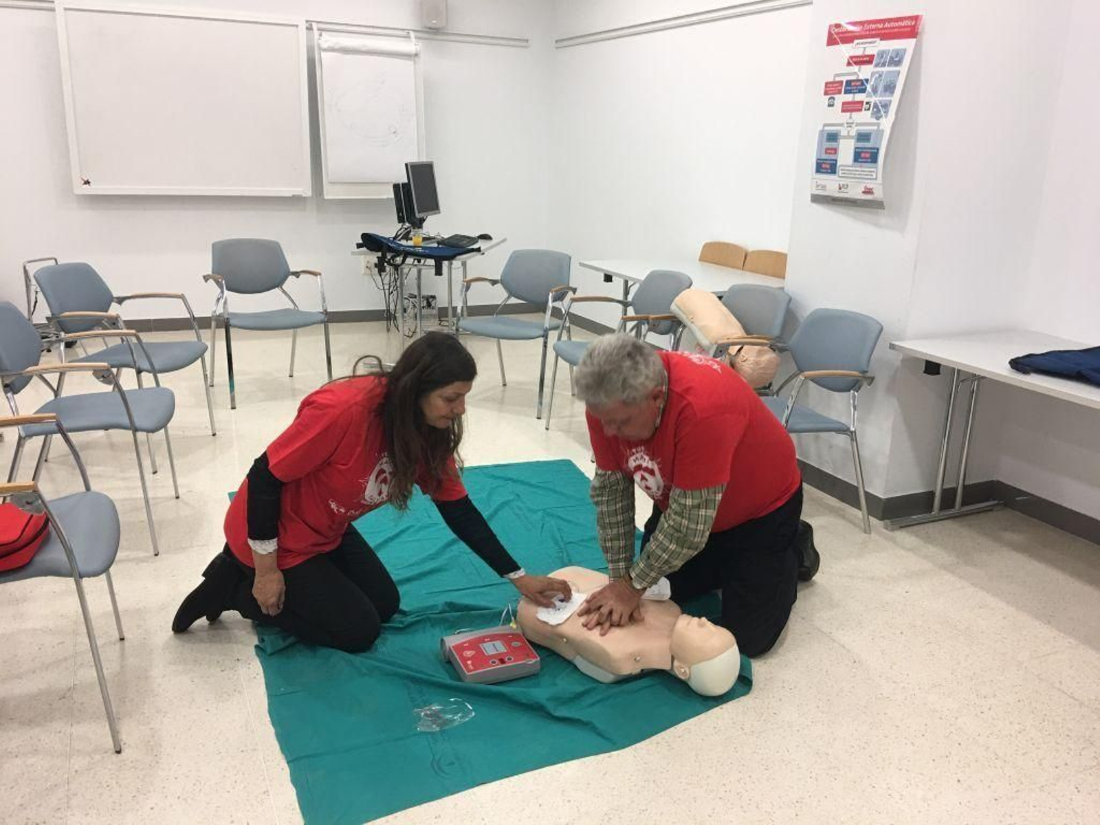 Un facultativo explica cómo usar un desfibrilador en un curso de RCP.