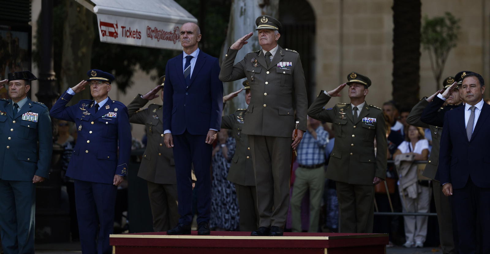 El izado de bandera y desfile militar por el centro de Sevilla, en imágenes