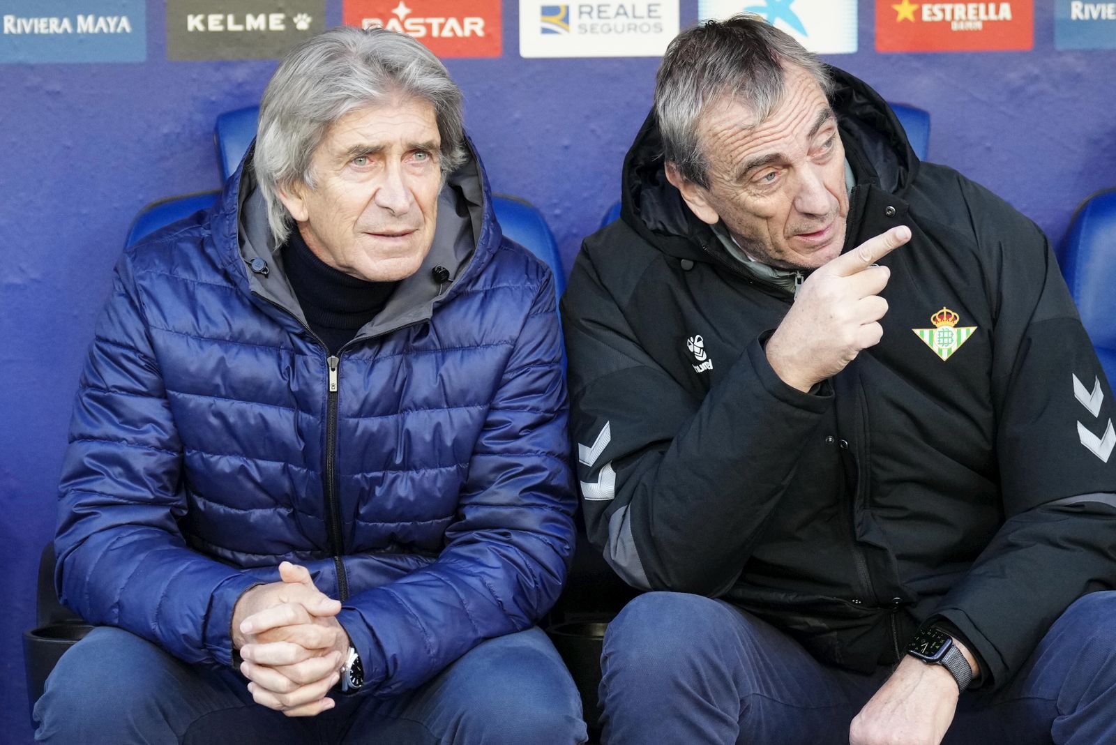Pellegrini escucha a Rubén Cousillas antes del inicio de un partido.