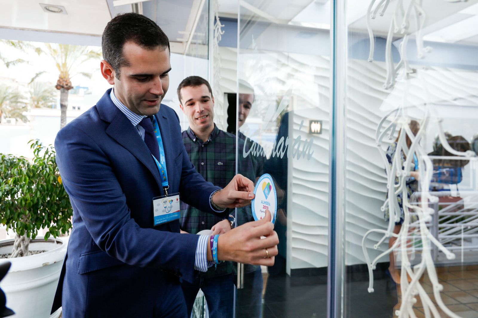 El alcalde de Almería, Ramón Fernández-Pacheco, coloca el distintivo de la candidatura en el restaurante Catamarán.