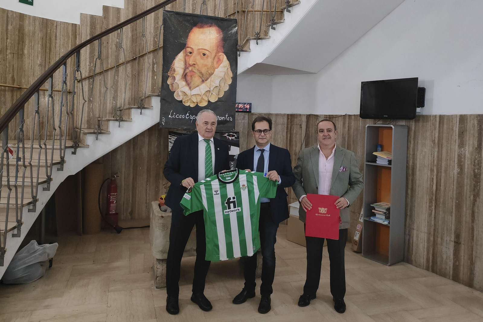 Rafael Gordillo sujeta la camiseta del Betis junto al director del Liceo Español Cervantes (Roma) y al Teniente de Alcalde Delegado del área de economía, comercio y turismo de Sevilla, Francisco Javier Paéz.