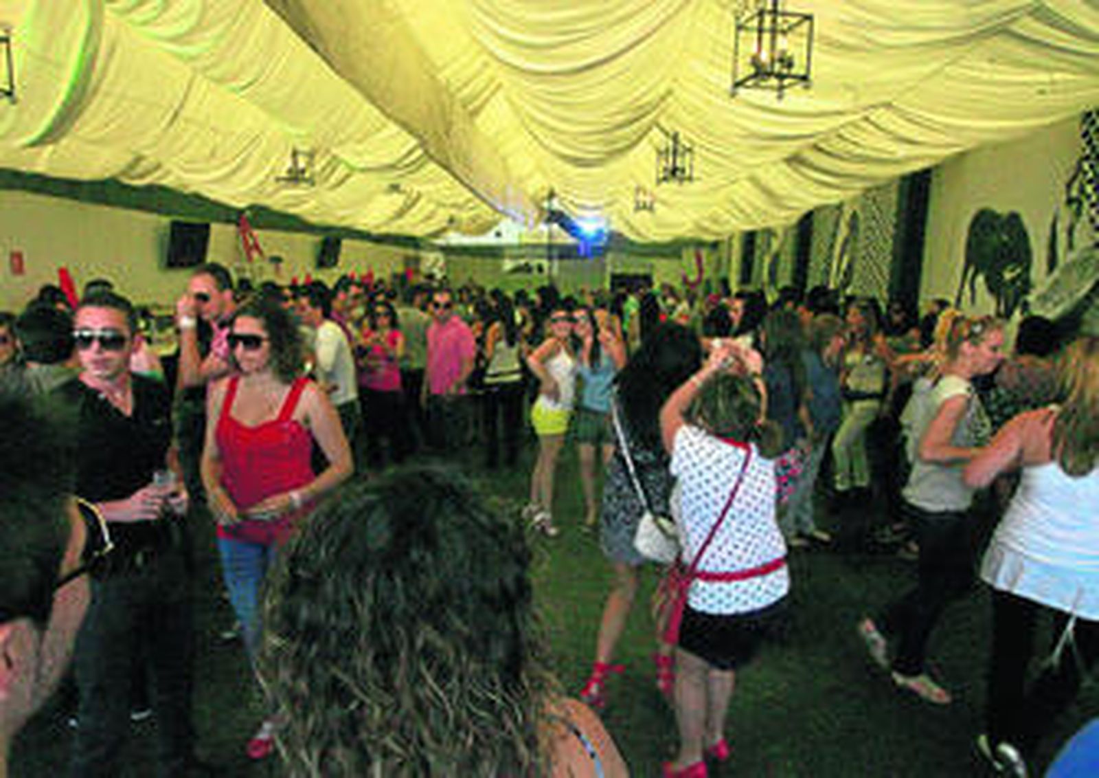 Varios grupos de jóvenes bailan en el interior de una de las casetas a primera hora de la tarde.